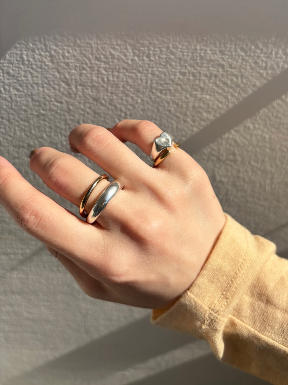 シルバー系のリング、ゴールド系のネックレス、ゴールド系のリングを着用したレディースの春コーディネートの1枚目の写真