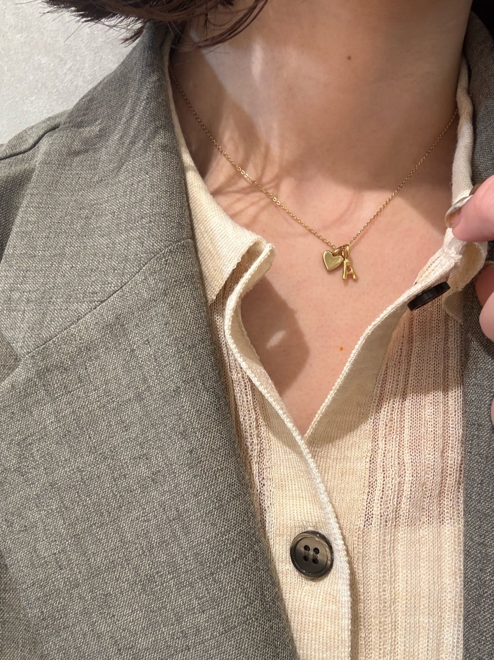 ゴールド系のネックレス、ゴールド系のチャームを着用したレディースの春コーディネートの1枚目の写真