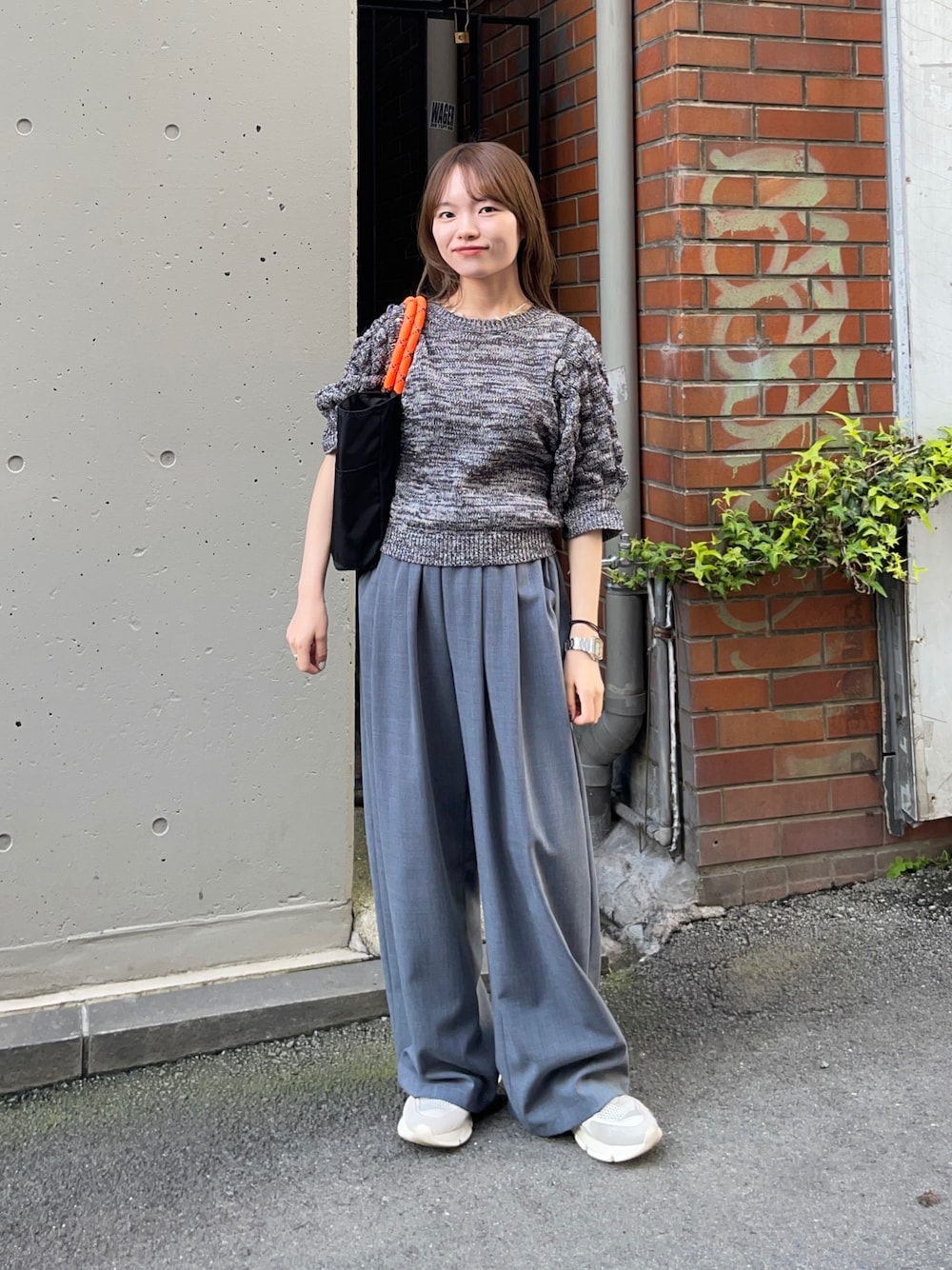 グレー系のニット/セーター、ブラック系のトートバッグ、グレー系のその他パンツを着用したレディースの春コーディネートの1枚目の写真