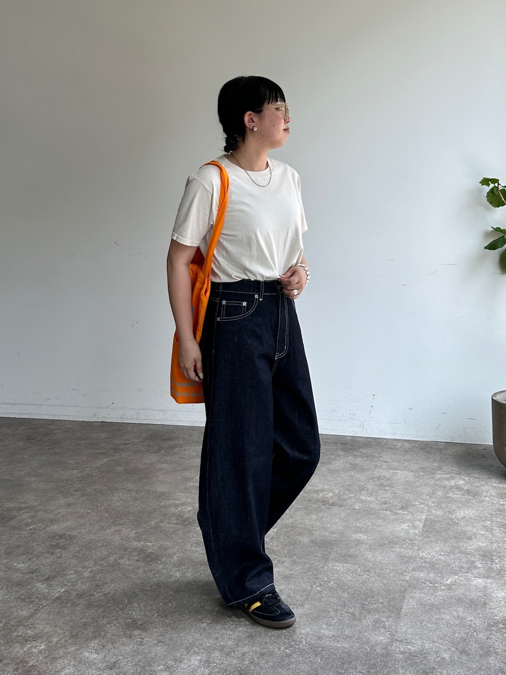 ホワイト系のTシャツ/カットソー、ブルー系のデニムパンツ、オレンジ系のトートバッグを着用したレディースの夏コーディネートの1枚目の写真