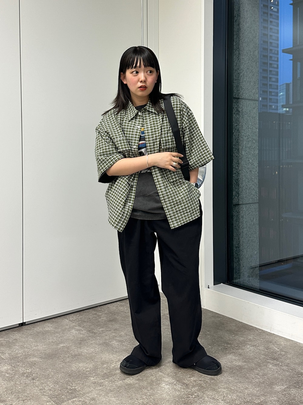 グリーン系のシャツ/ブラウス、ブラック系のその他パンツ、シルバー系のボディバッグ/ウエストポーチを着用したレディースの春コーディネートの1枚目の写真