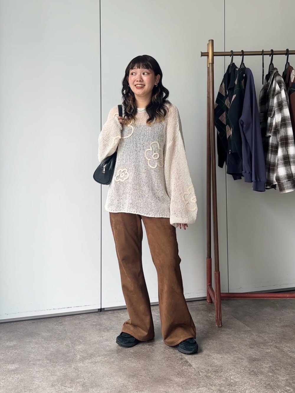 ホワイト系のニット/セーター、ブラック系のボストンバッグを着用したレディースの夏コーディネートの1枚目の写真