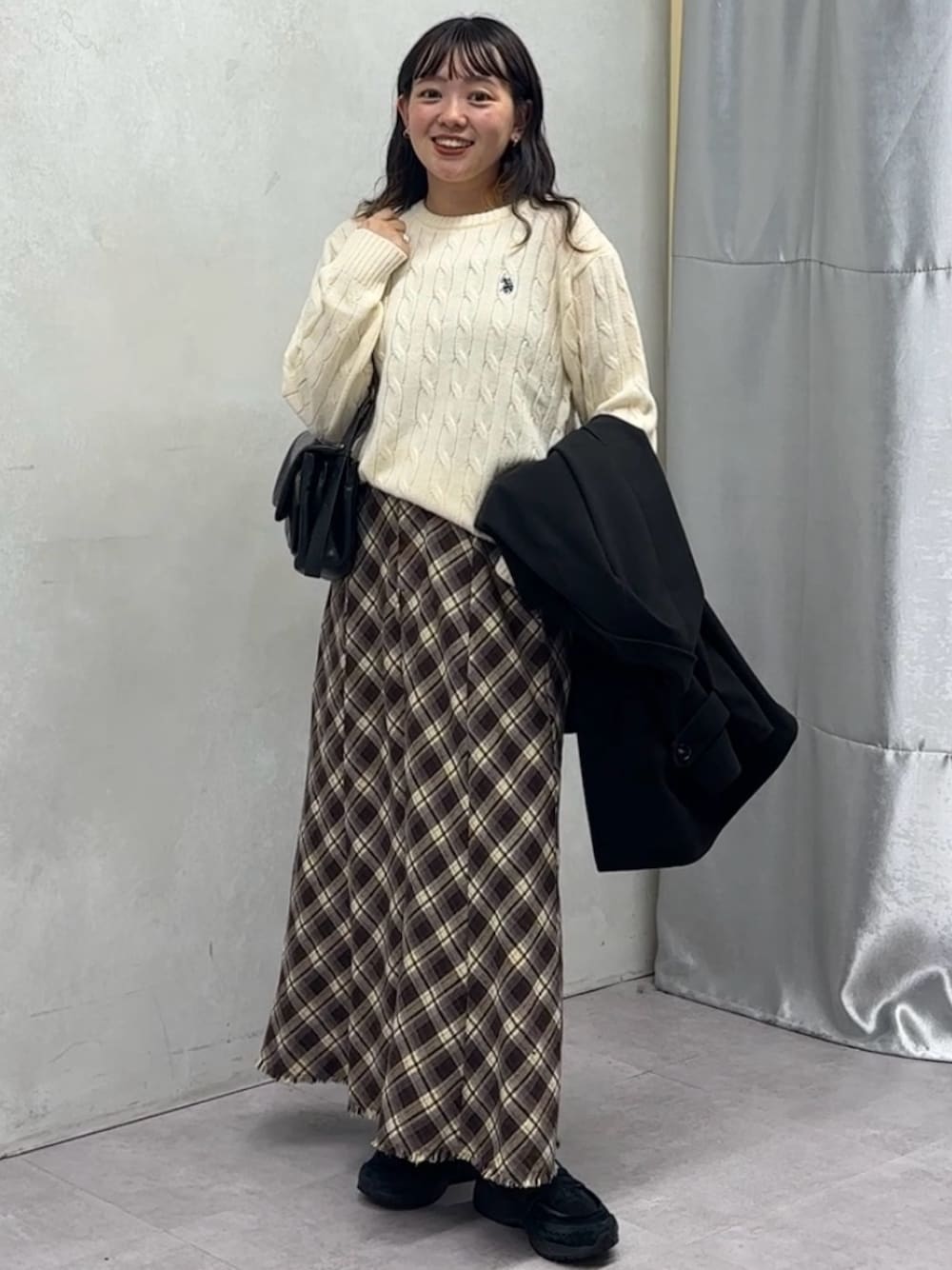 ブラック系のその他アウター、ホワイト系のニット/セーターを着用したレディースの秋コーディネートの1枚目の写真