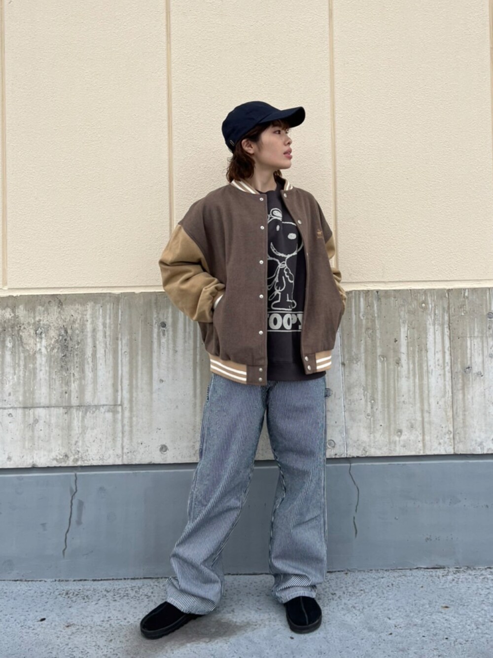 ベージュ系のスタジャン、ブラック系のニット/セーター、ブルー系のデニムパンツを着用したレディースの冬コーディネートの1枚目の写真