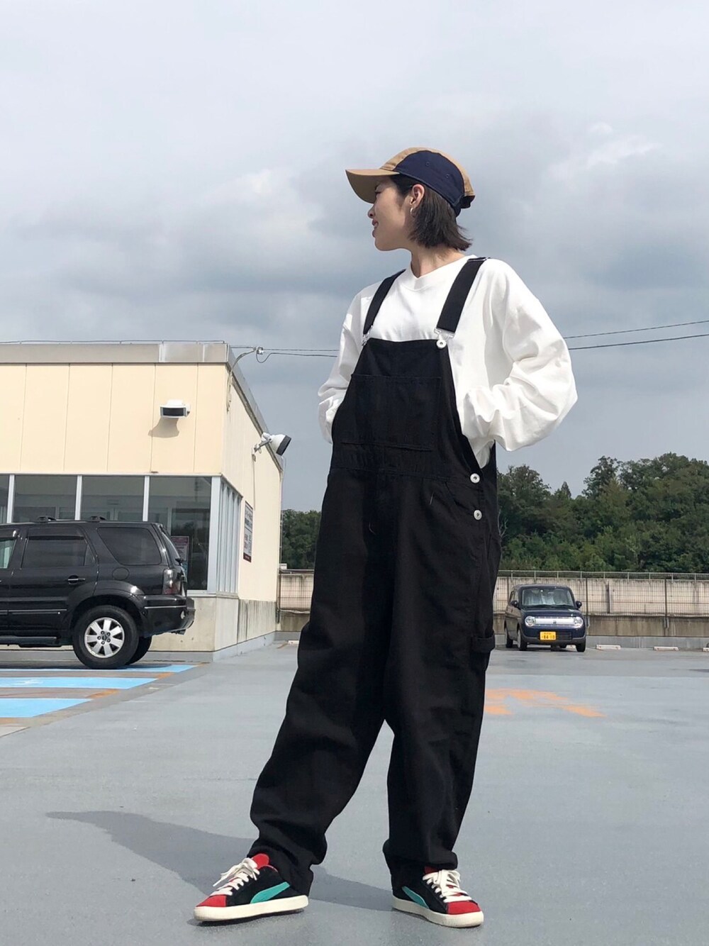 ブルー系のサロペット/オーバーオール、ホワイト系のTシャツ/カットソー、ブルー系のキャップを着用したレディースの秋コーディネートの1枚目の写真