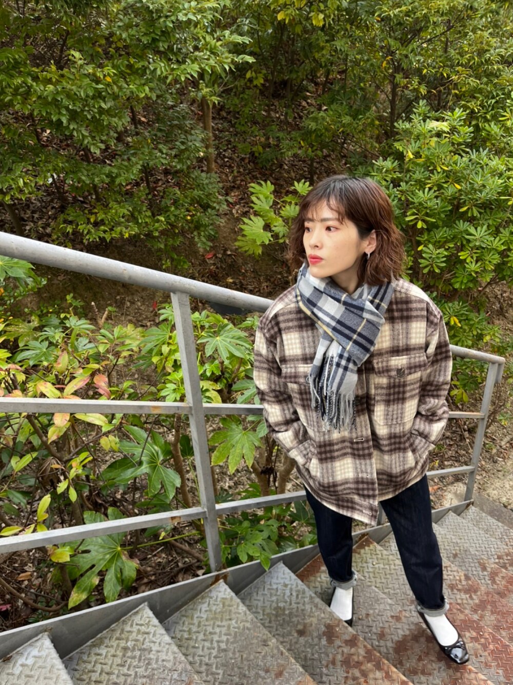 ブラウン系のその他アウター、ブルー系のデニムパンツ、グレー系のマフラーを着用したレディースの冬コーディネートの1枚目の写真