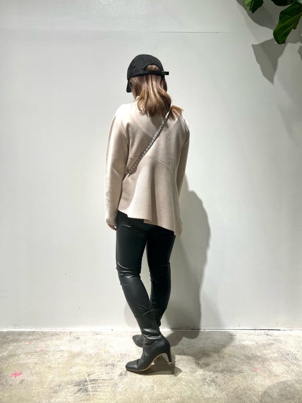 ブラック系のその他パンツ、ベージュ系のニット/セーター、ブラック系のブーツを着用したレディースの秋コーディネートの1枚目の写真