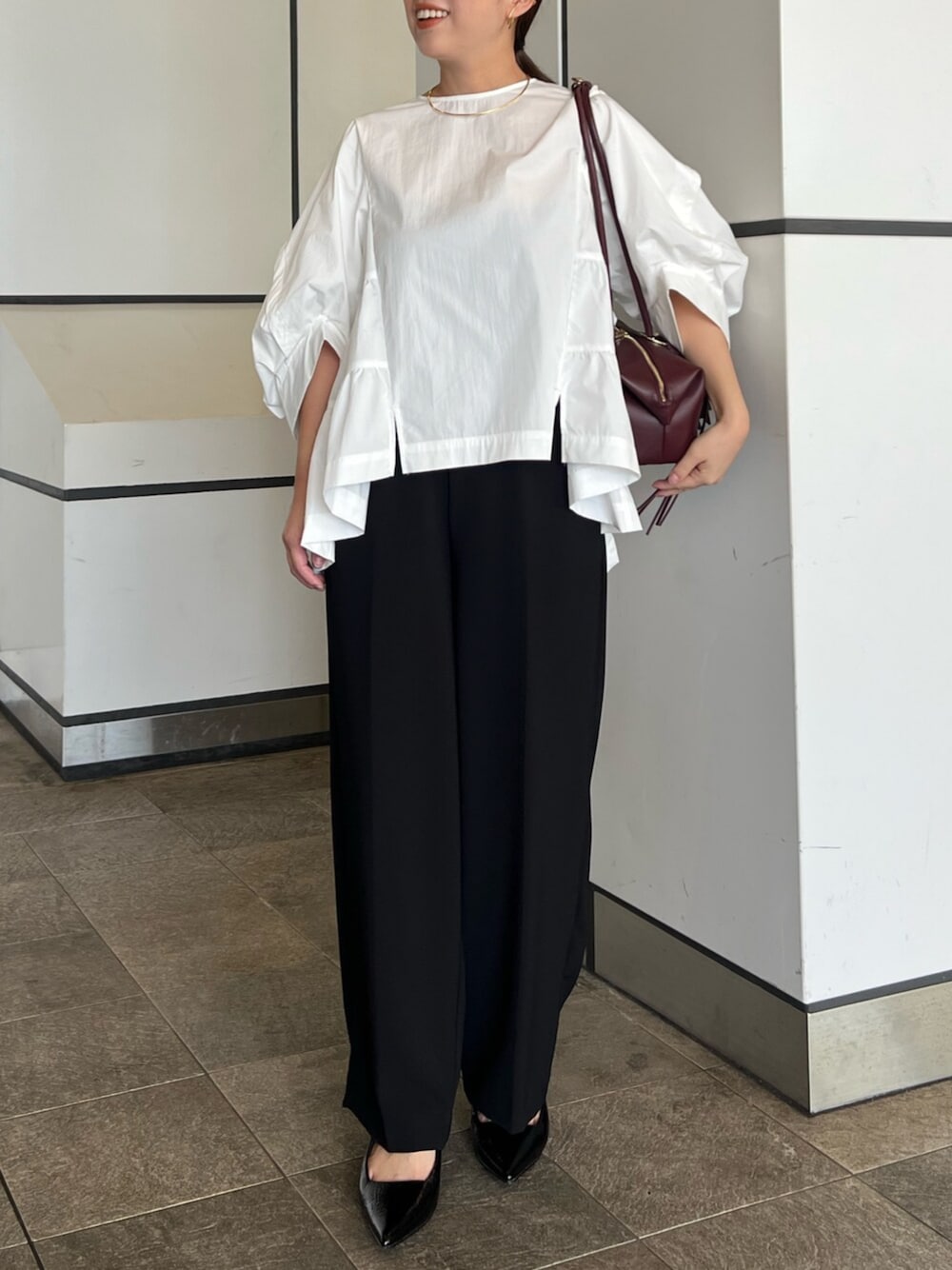 ホワイト系のシャツ/ブラウス、ブラック系のその他パンツ、レッド系のボストンバッグを着用したレディースの秋コーディネートの1枚目の写真