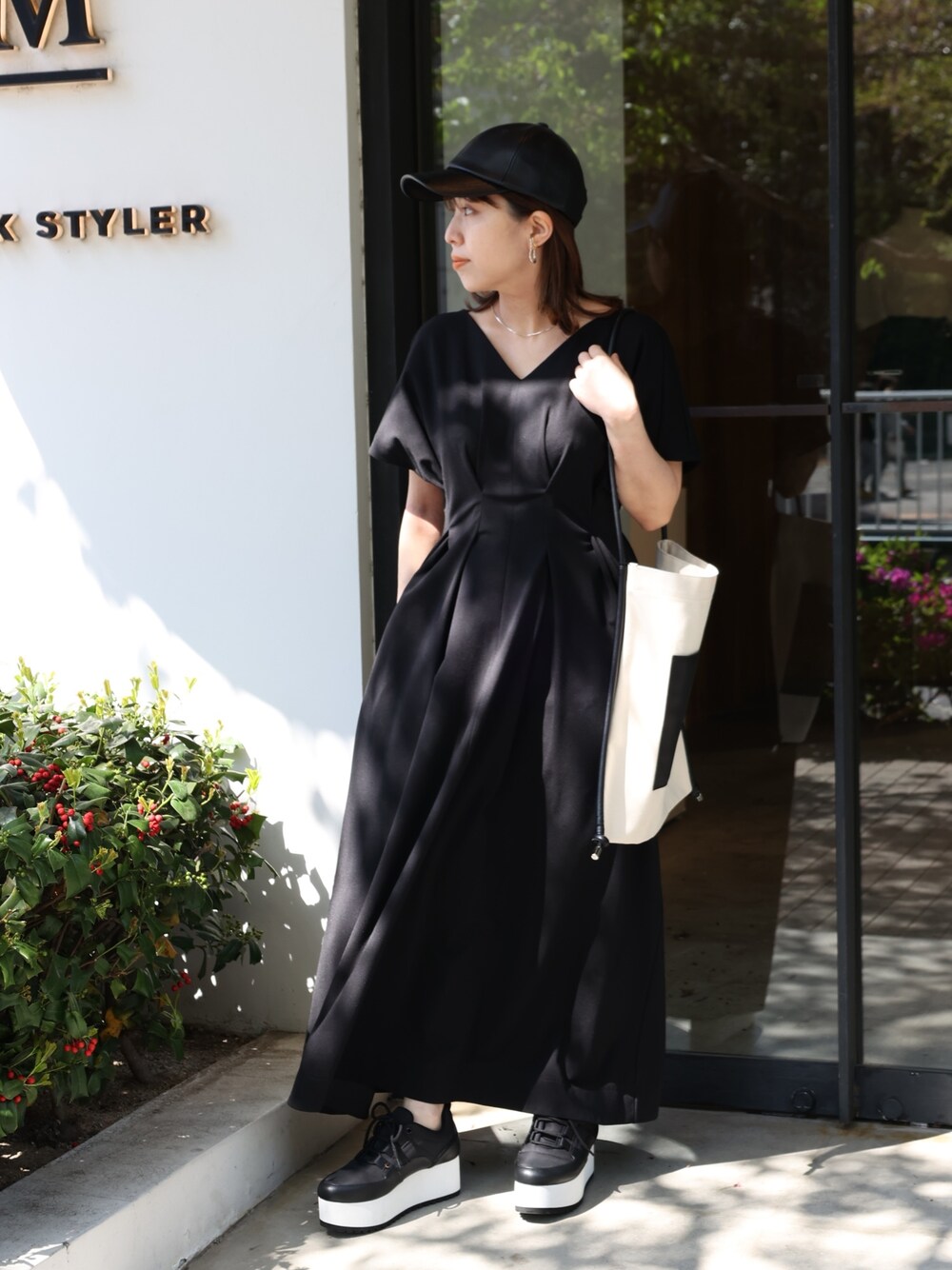 ブラック系のスニーカー、その他のトートバッグ、ブラック系のワンピースを着用したレディースの春コーディネートの1枚目の写真