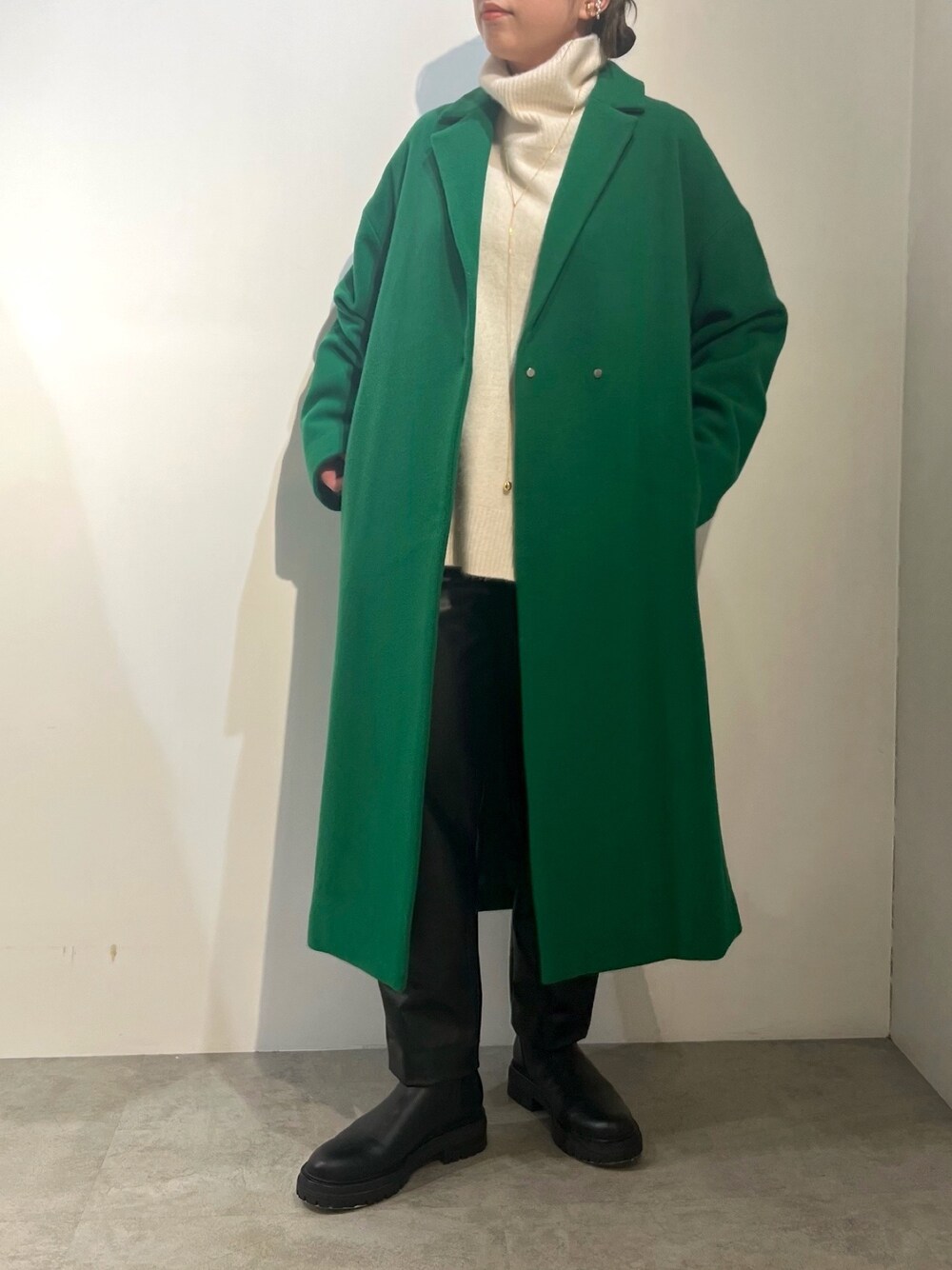ブラック系のその他パンツ、ホワイト系のニット/セーター、グリーン系のチェスターコートを着用したレディースの冬コーディネートの1枚目の写真
