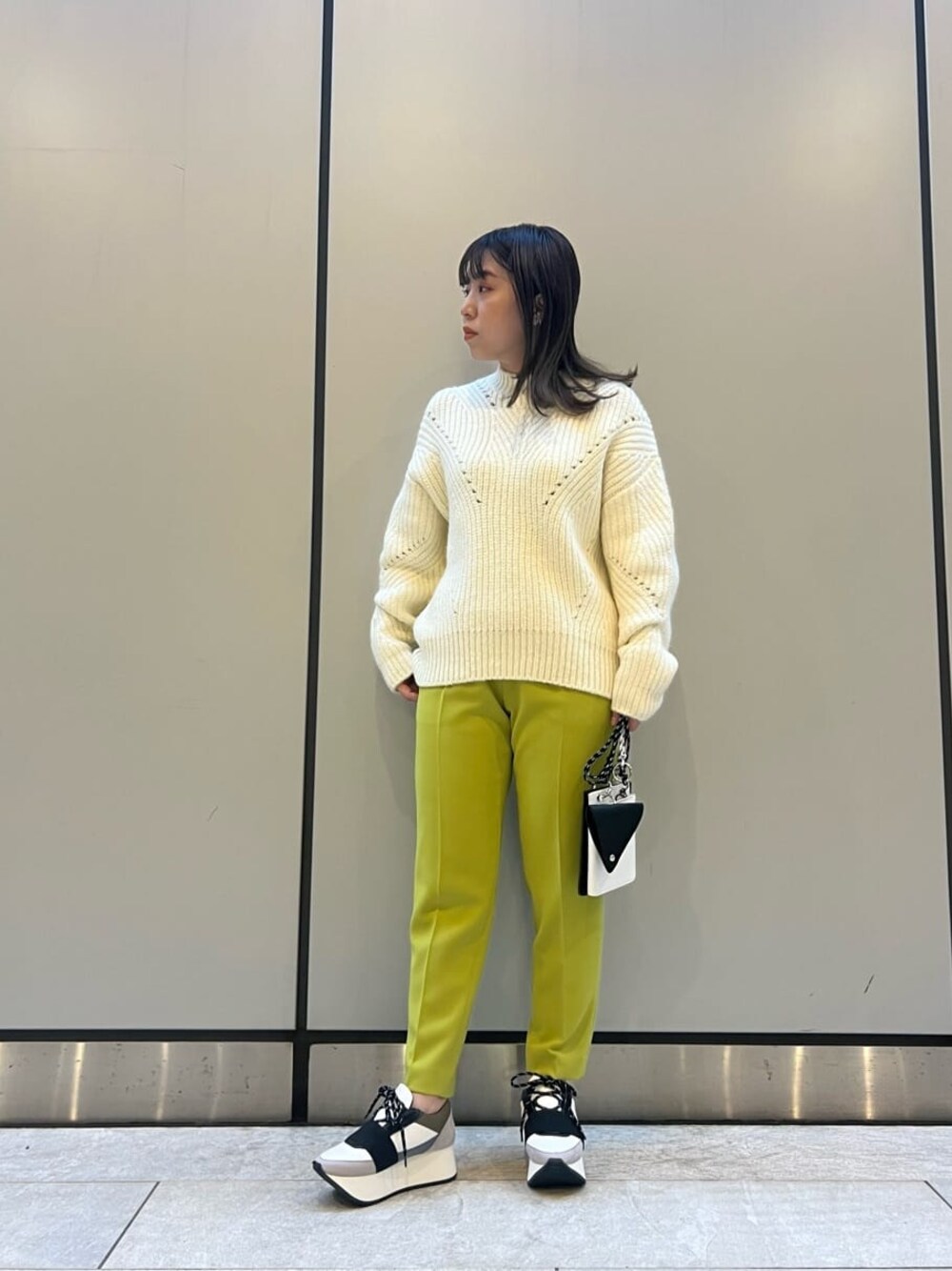 グリーン系のその他パンツ、ブラック系のショルダーバッグ、ホワイト系のニット/セーターを着用したレディースの秋コーディネートの1枚目の写真