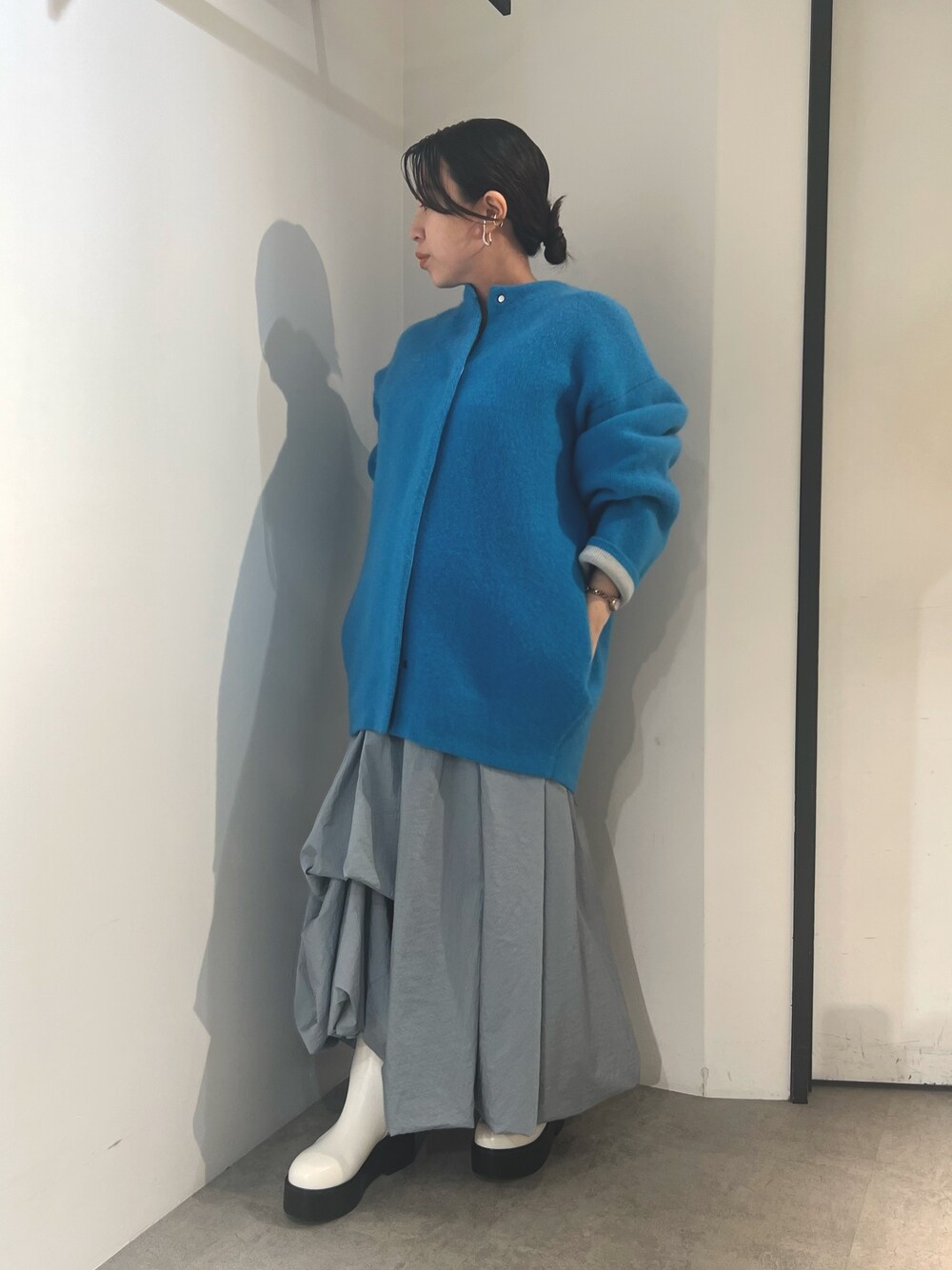 ブルー系のノーカラージャケット、ブルー系のスカート、ホワイト系のブーツを着用したレディースの夏コーディネートの1枚目の写真
