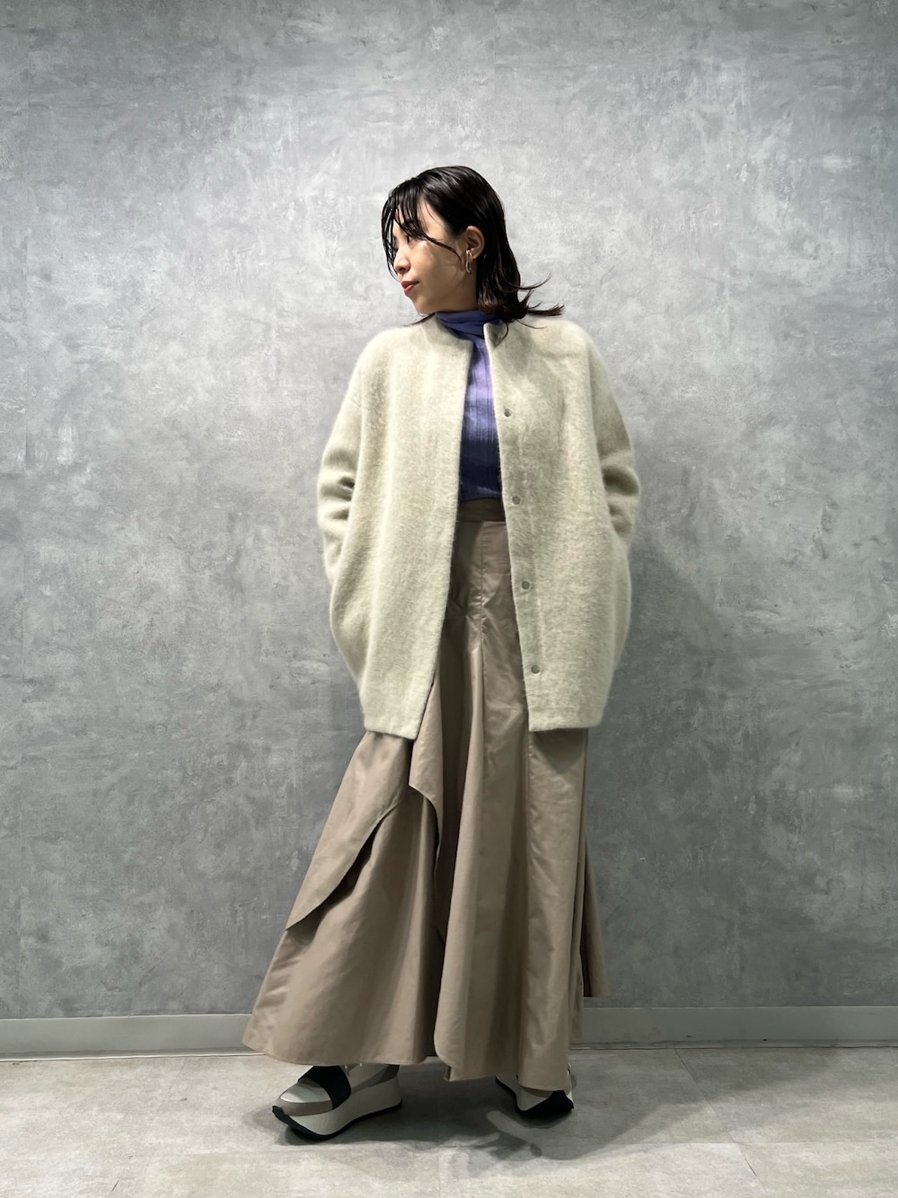 ホワイト系のノーカラージャケット、パープル系のニット/セーター、ベージュ系のスカートを着用したレディースの夏コーディネートの1枚目の写真