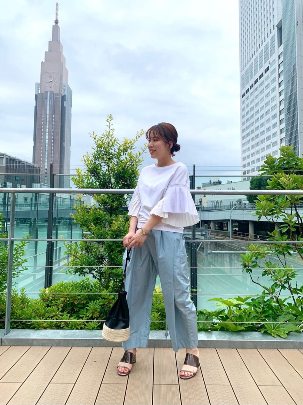 ブラック系のハンドバッグ、ホワイト系のTシャツ/カットソー、ブルー系のその他パンツを着用したレディースの夏コーディネートの1枚目の写真
