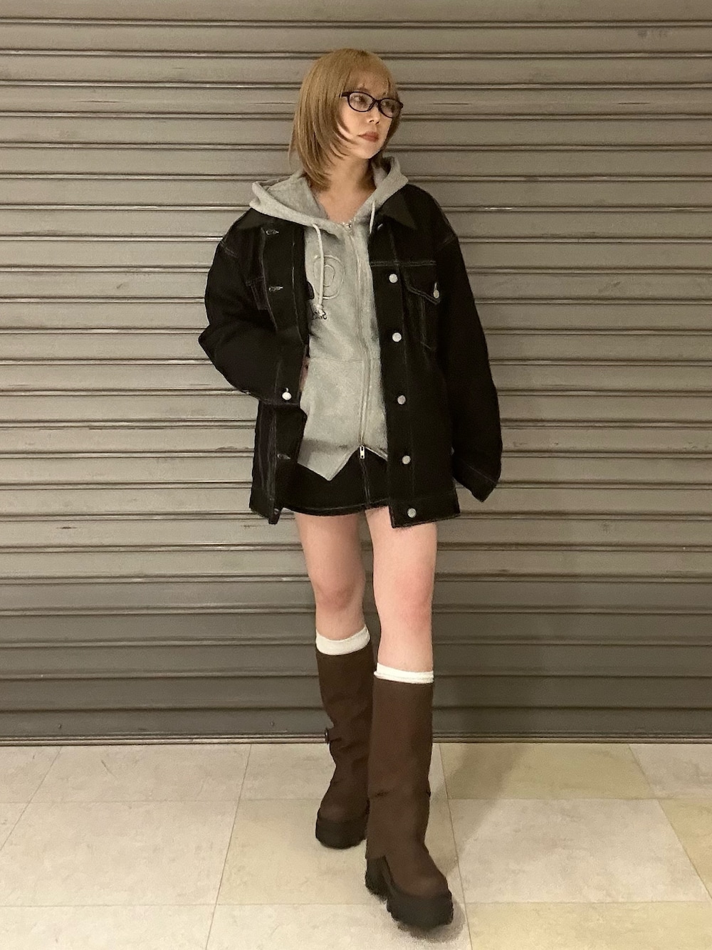 ブルー系のブルゾン、グレー系のパーカー、ブルー系のスカートを着用したレディースの冬コーディネートの1枚目の写真