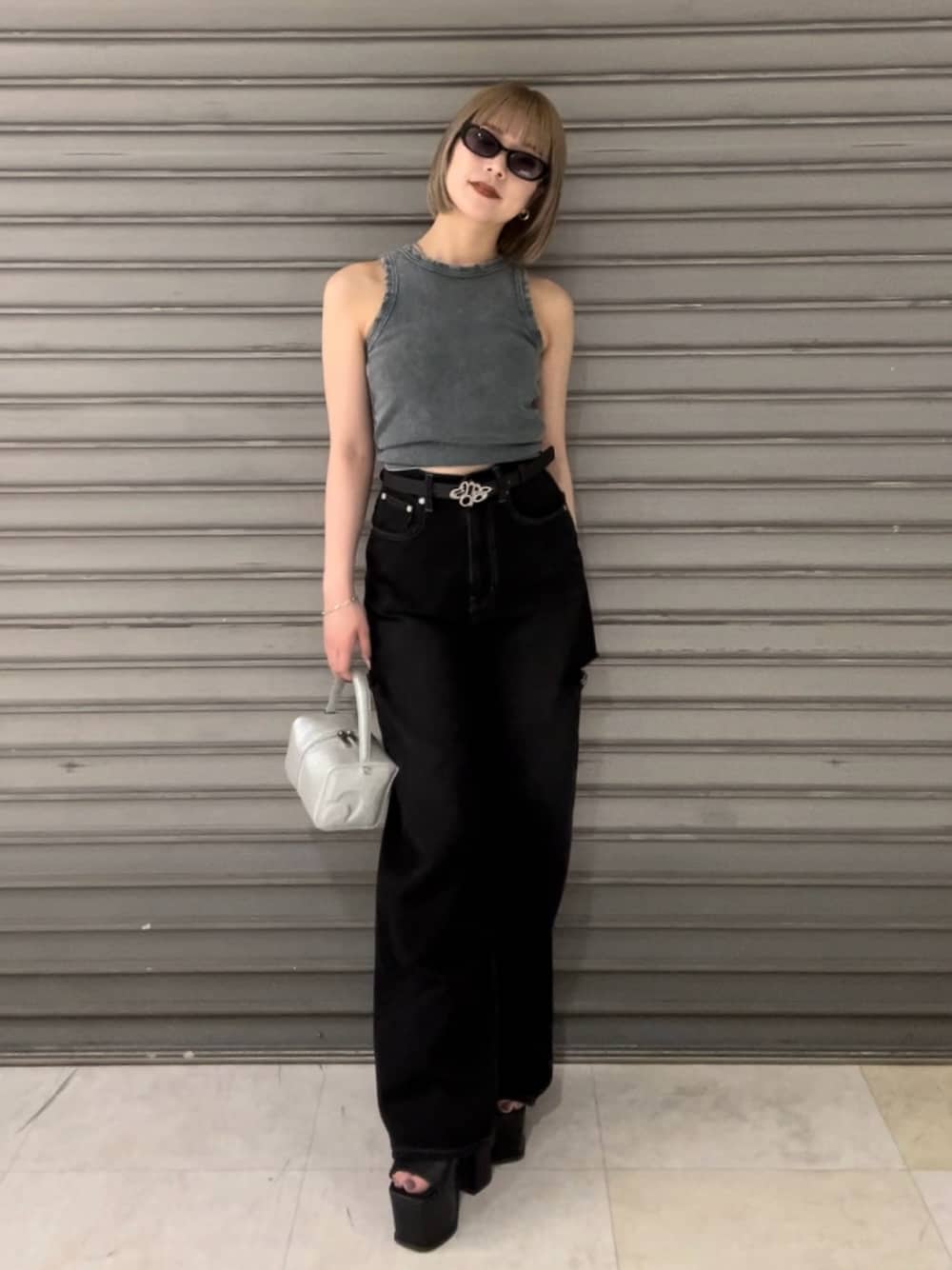 ブルー系のタンクトップ、ブラック系のデニムパンツ、ブラック系のハンドバッグを着用したレディースの夏コーディネートの1枚目の写真