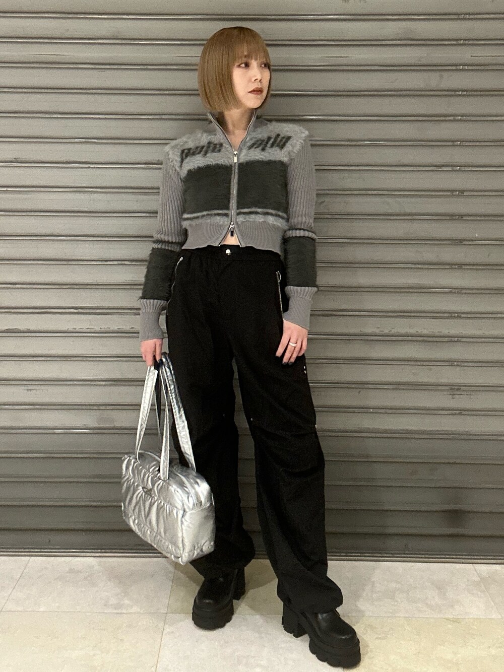 グレー系のニット/セーター、ブラック系のその他パンツ、シルバー系のボストンバッグを着用したレディースの冬コーディネートの1枚目の写真