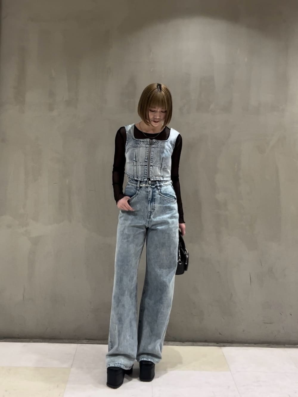 ブルー系のキャミソール、ブラック系のTシャツ/カットソー、ブルー系のデニムパンツを着用したレディースの春コーディネートの1枚目の写真