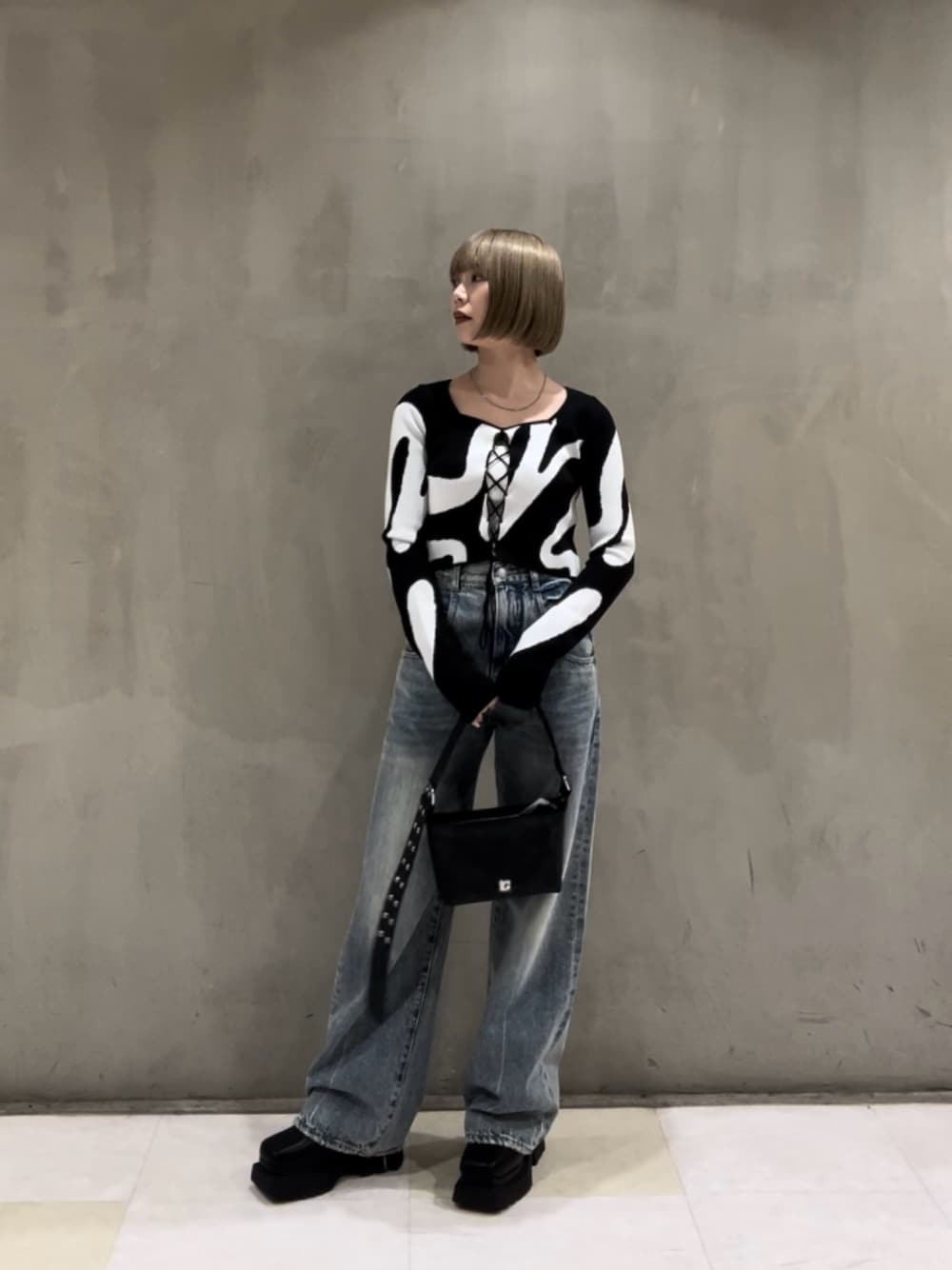 その他のニット/セーター、ホワイト系のキャミソール、ブラック系のショルダーバッグを着用したレディースの冬コーディネートの1枚目の写真