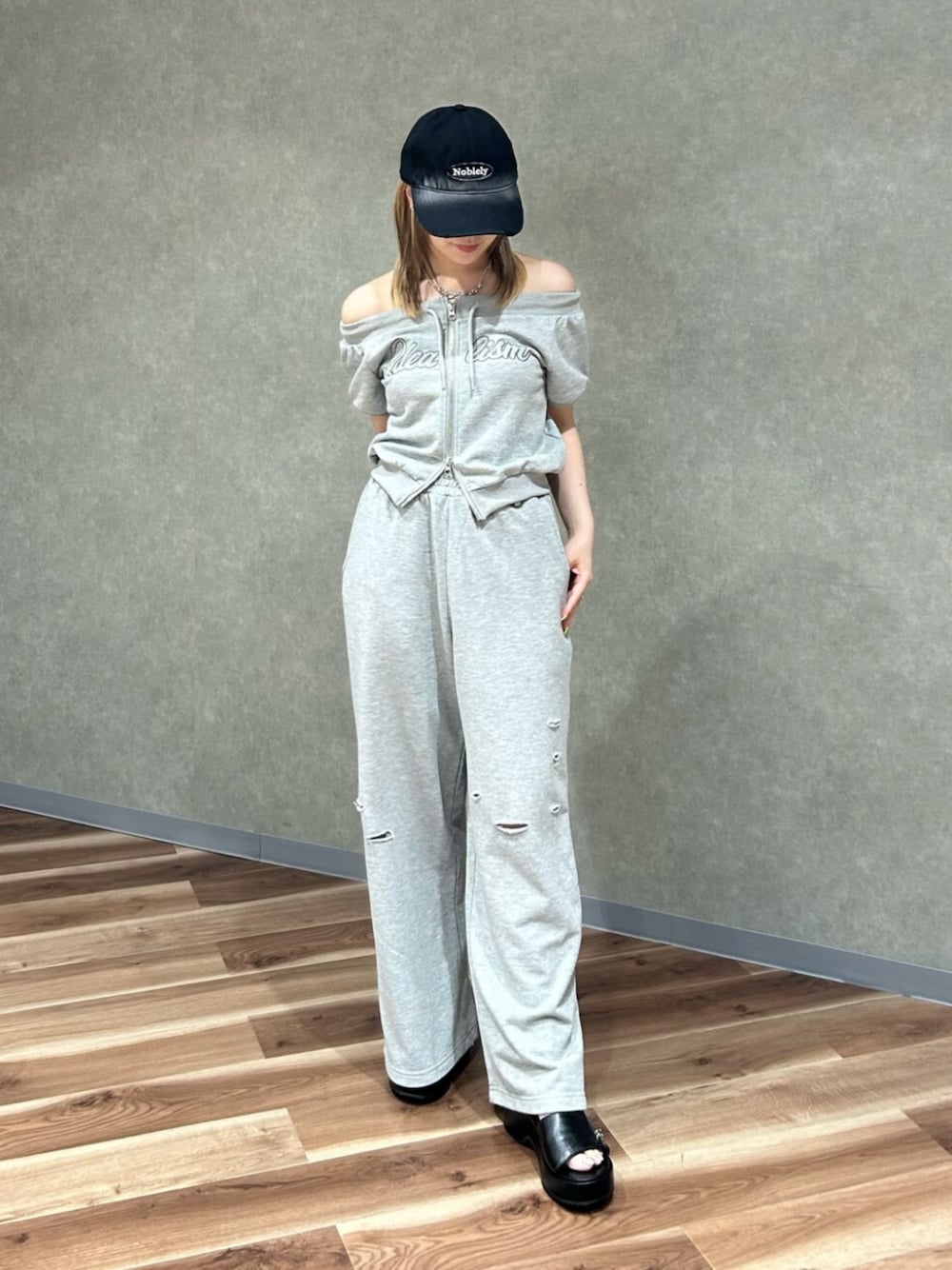 グレー系のスウェット、グレー系のスウェットパンツ、ブラック系のサンダルを着用したレディースの夏コーディネートの1枚目の写真