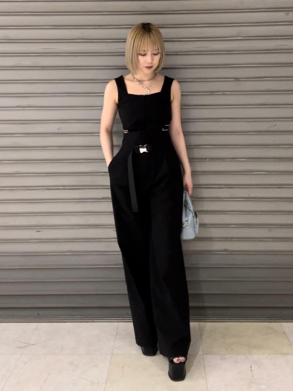 ブラック系のつなぎ/オールインワン、ブラック系のサンダル、ブルー系のハンドバッグを着用したレディースの春コーディネートの1枚目の写真
