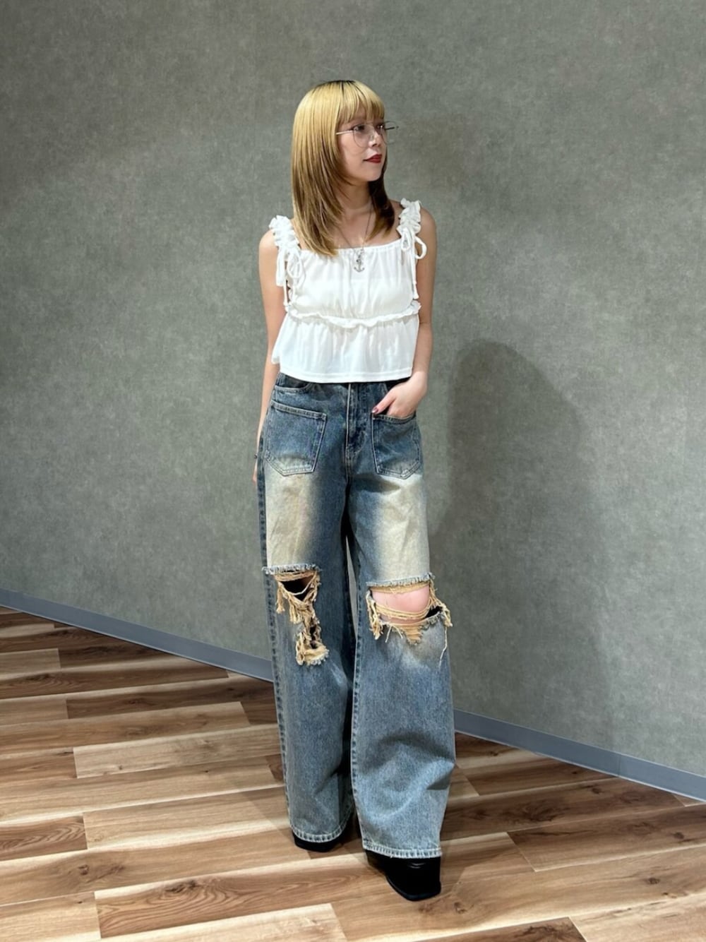 ホワイト系のタンクトップ、ブルー系のデニムパンツ、ブラック系のサンダルを着用したレディースの夏コーディネートの1枚目の写真