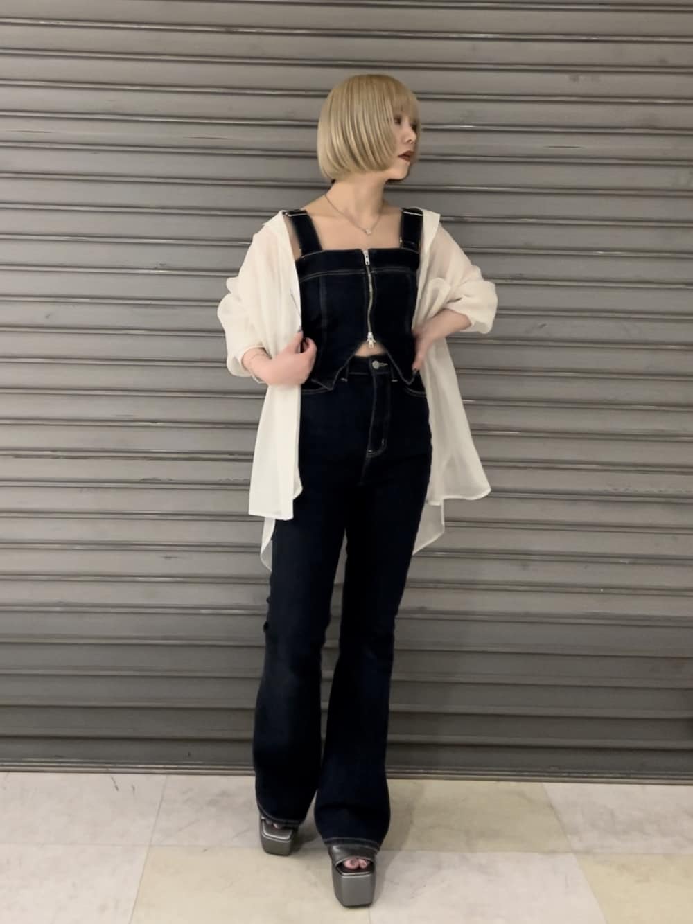 ブルー系のサロペット/オーバーオール、ホワイト系のシャツ/ブラウス、シルバー系のサンダルを着用したレディースの春コーディネートの1枚目の写真