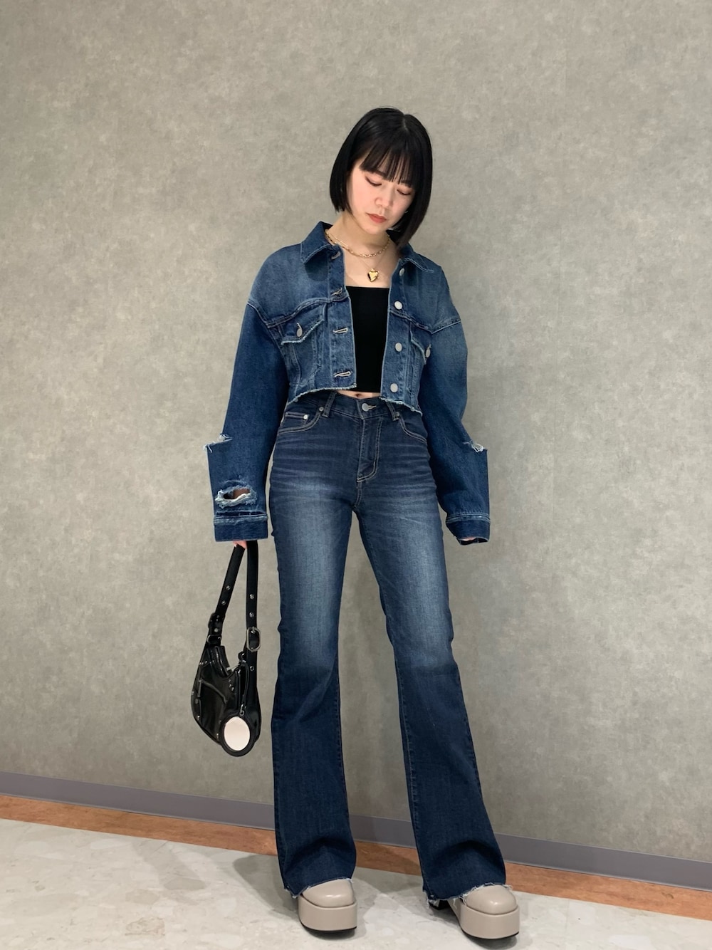 ブルー系のデニムパンツ、ブルー系のデニムジャケット、ブラック系のキャミソールを着用したレディースの春コーディネートの1枚目の写真