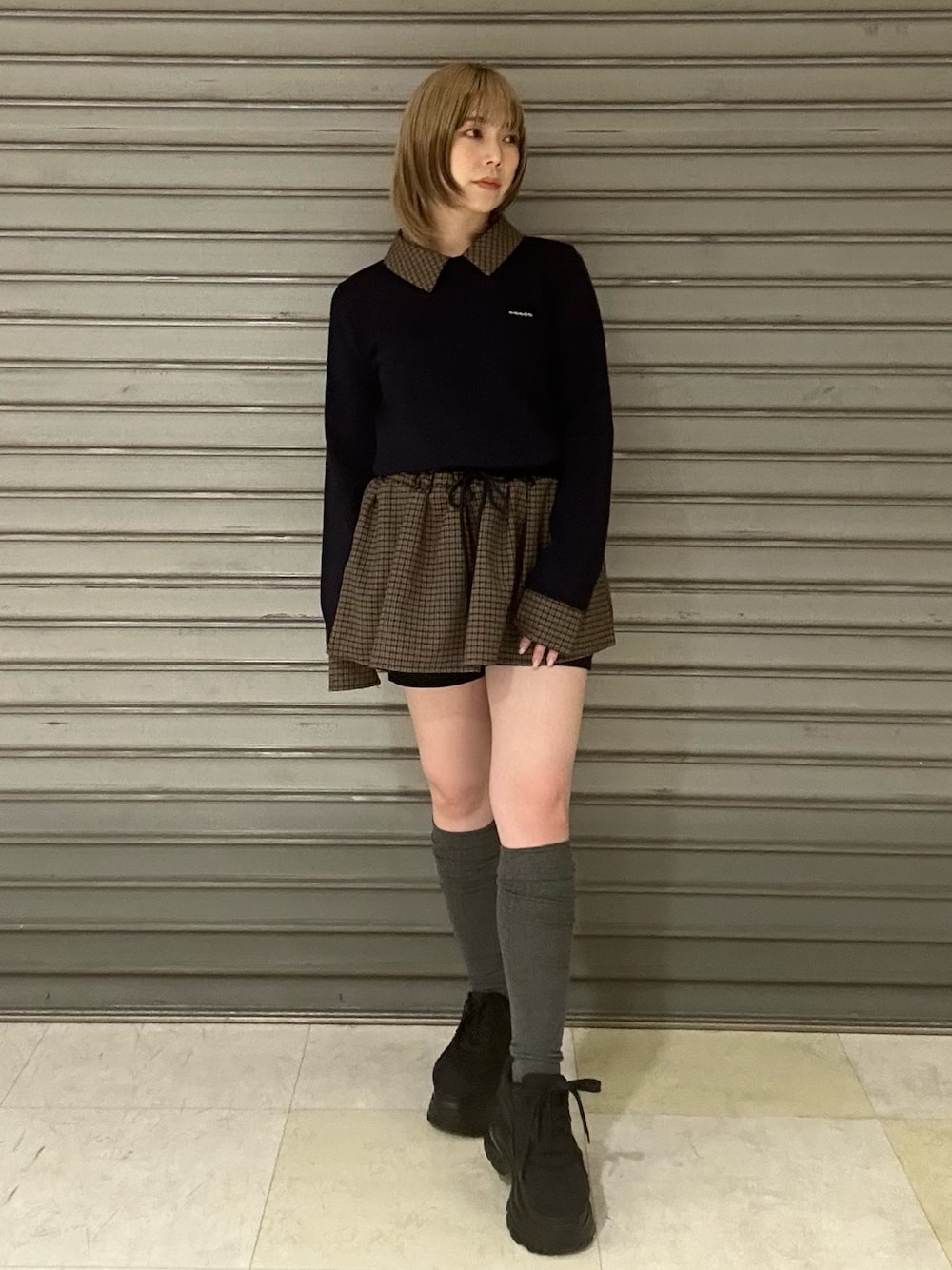 ブラック系のスニーカー、ブルー系のシャツ/ブラウス、ブルー系のスカートを着用したレディースの冬コーディネートの1枚目の写真