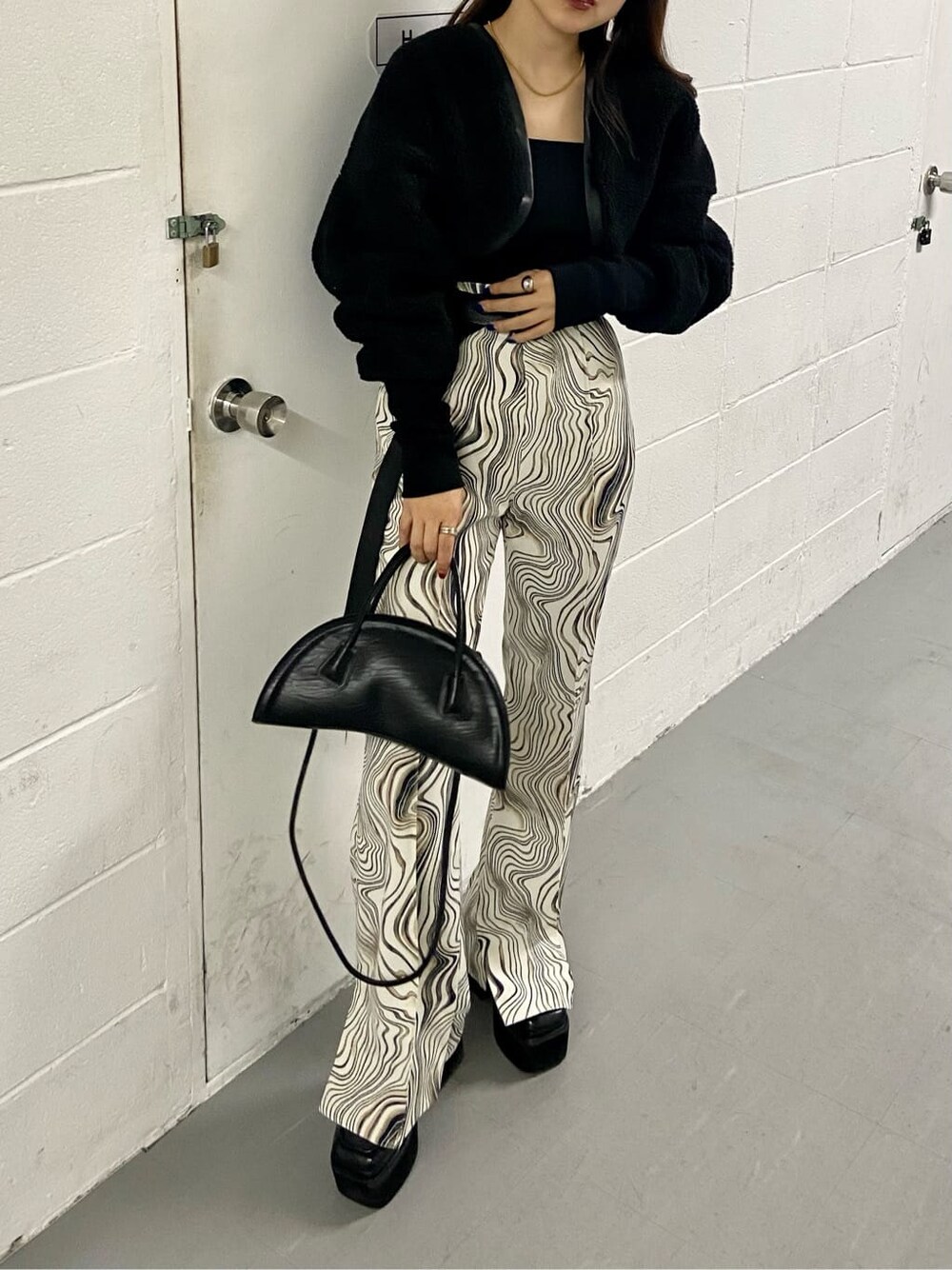 ブラック系のローファー、ブラック系のカーディガン/ボレロ、ブラック系のハンドバッグを着用したレディースの秋コーディネートの1枚目の写真