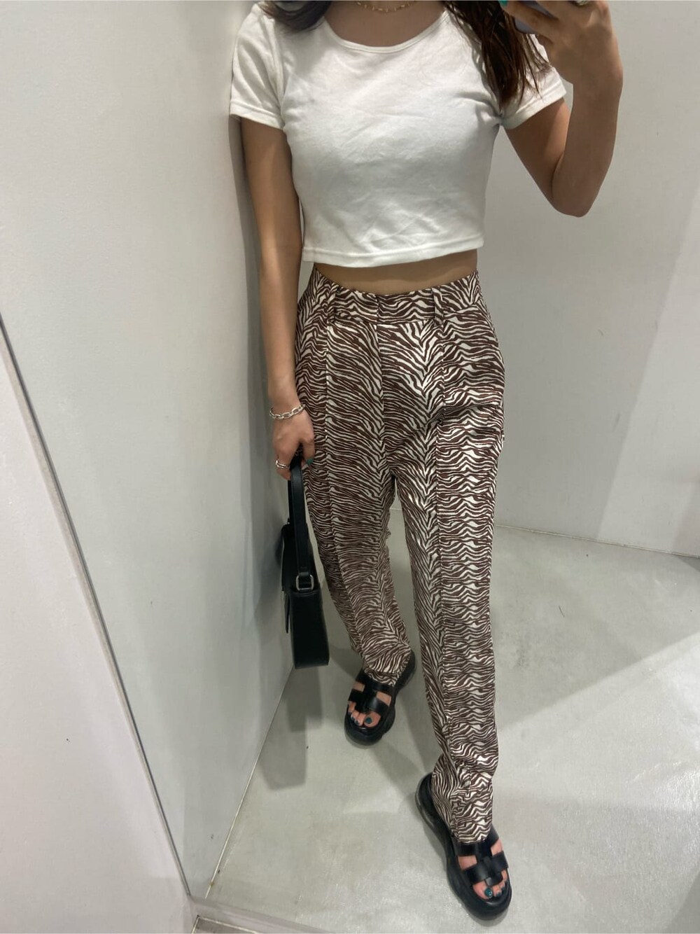 ホワイト系のTシャツ/カットソー、ブラック系のサンダル、その他のその他パンツを着用したレディースの春コーディネートの1枚目の写真