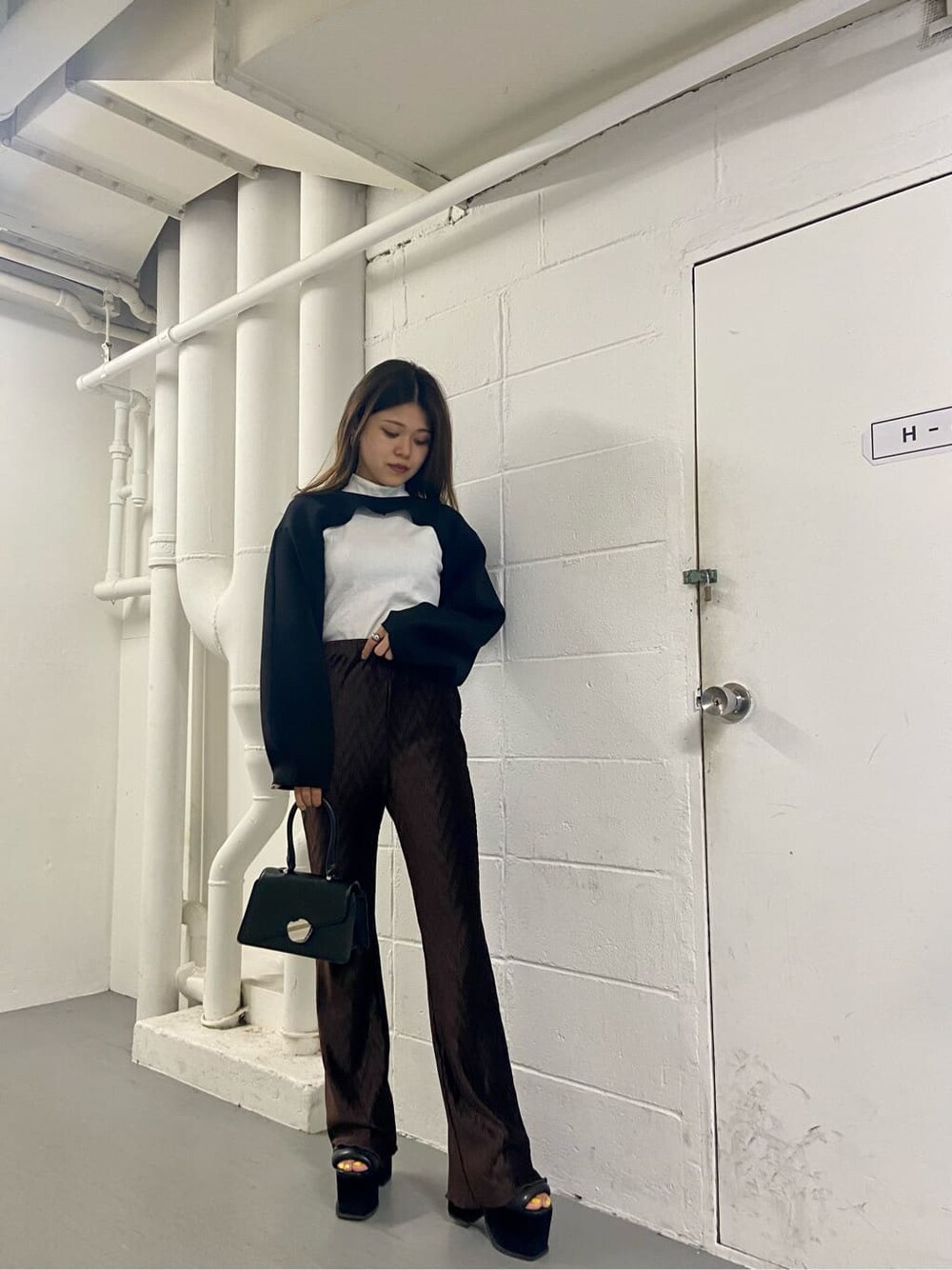 ブラック系のハンドバッグ、ブラック系のTシャツ/カットソー、ホワイト系のTシャツ/カットソーを着用したレディースの夏コーディネートの1枚目の写真