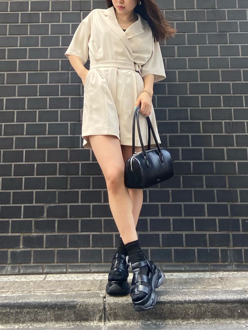 ブラック系のボストンバッグ、ブラック系のキャミソール、ホワイト系のつなぎ/オールインワンを着用したレディースの春コーディネートの1枚目の写真