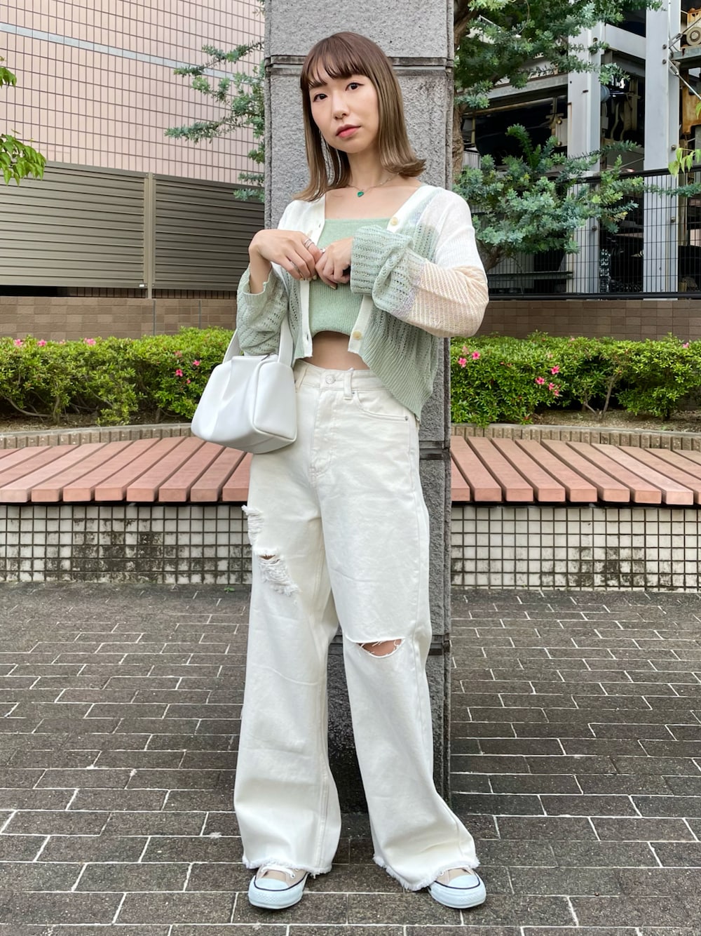 グリーン系のカーディガン/ボレロ、グリーン系のキャミソール、ホワイト系のデニムパンツを着用したレディースの春コーディネートの1枚目の写真