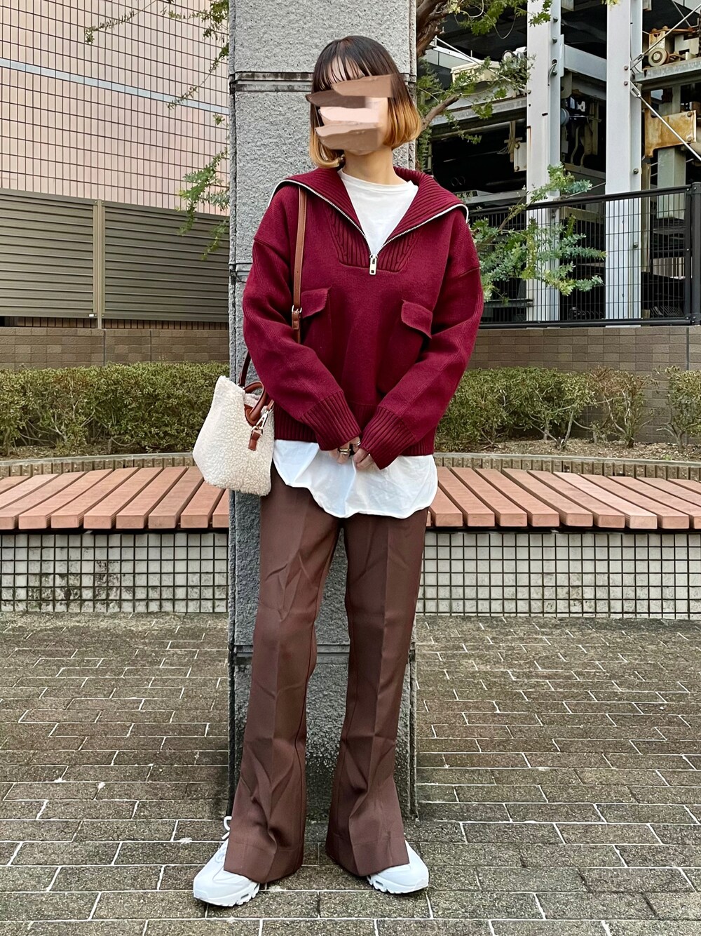 レッド系のニット/セーター、ホワイト系のTシャツ/カットソー、ホワイト系のショルダーバッグを着用したレディースの冬コーディネートの1枚目の写真