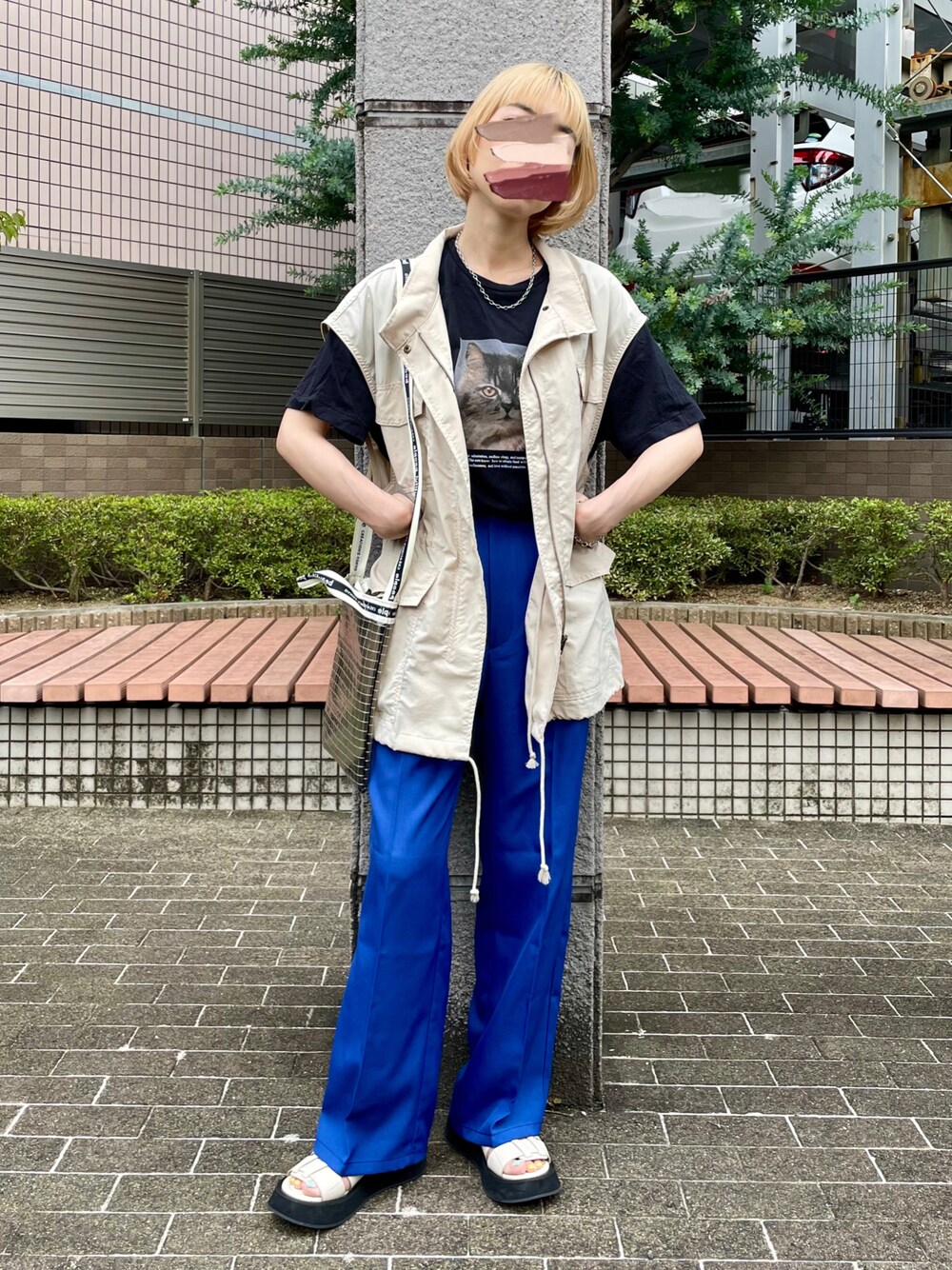 ベージュ系のベスト、ブルー系のスラックス、ブラック系のTシャツ/カットソーを着用したレディースの夏コーディネートの1枚目の写真