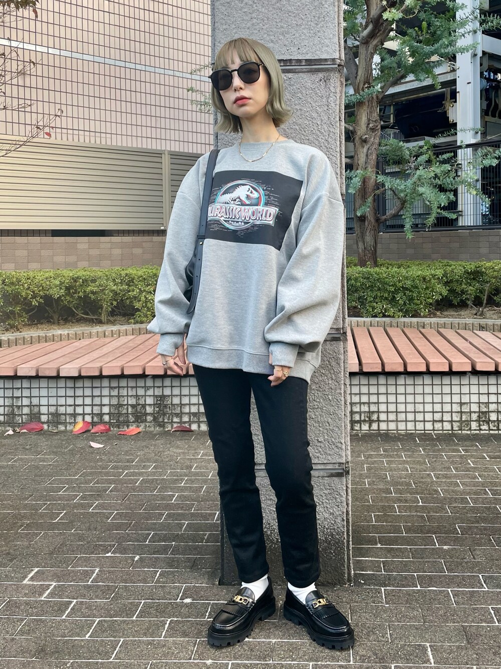 グレー系のスウェット、ブラック系のデニムパンツ、ブラック系のローファーを着用したレディースの秋コーディネートの1枚目の写真