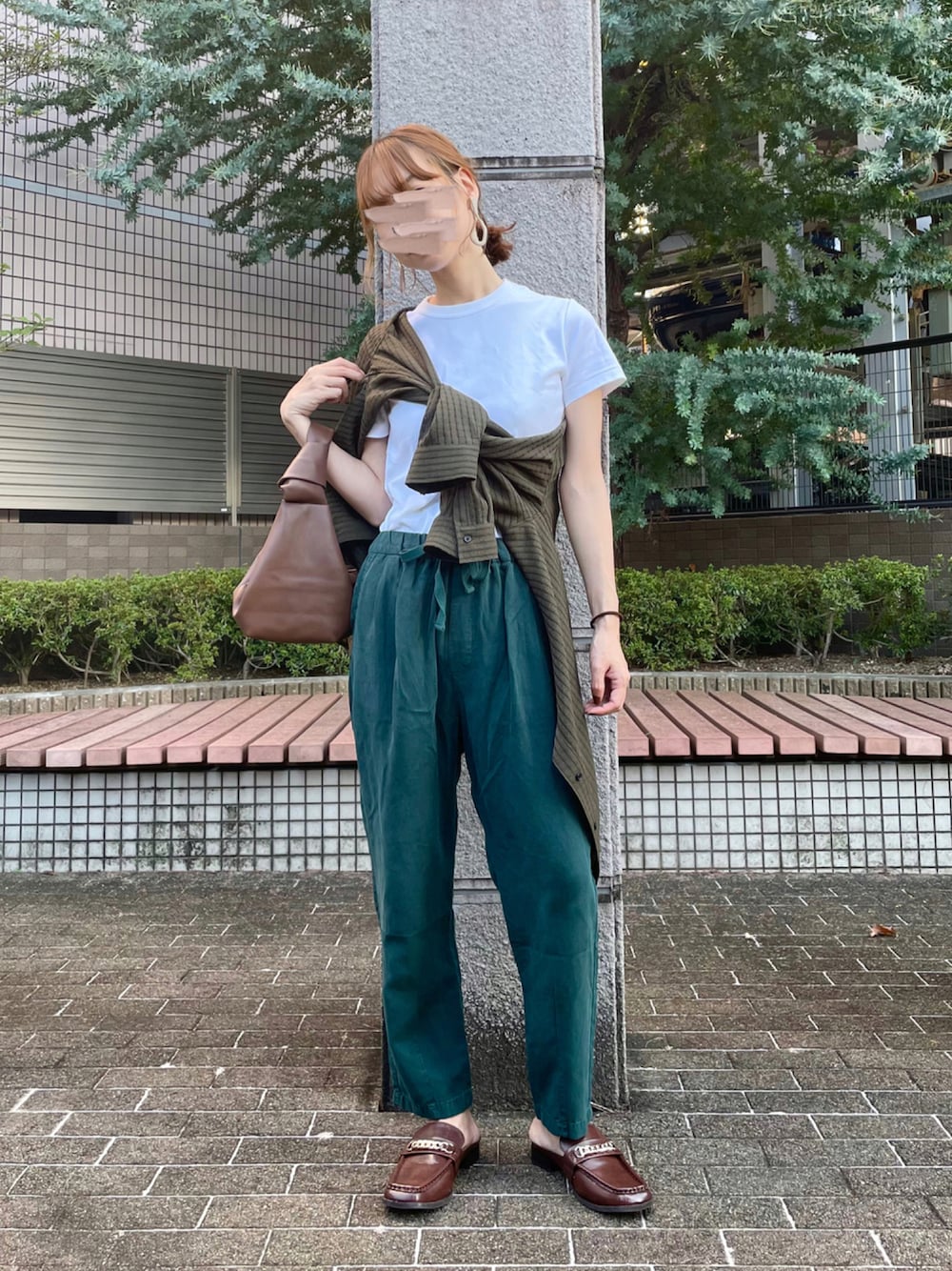 ブラウン系のローファー、ブラック系のハンドバッグ、グリーン系のシャツ/ブラウスを着用したレディースの秋コーディネートの1枚目の写真