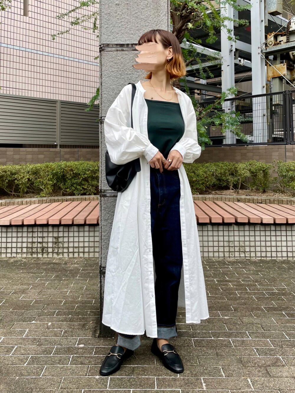 ブラック系のローファー、ホワイト系のシャツワンピース、ブルー系のデニムパンツを着用したレディースの秋コーディネートの1枚目の写真