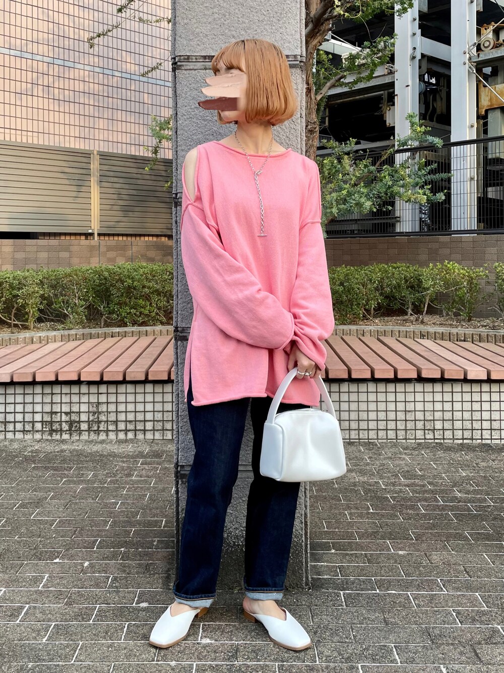 ピンク系のニット/セーター、ブルー系のデニムパンツ、ホワイト系のハンドバッグを着用したレディースの春コーディネートの1枚目の写真