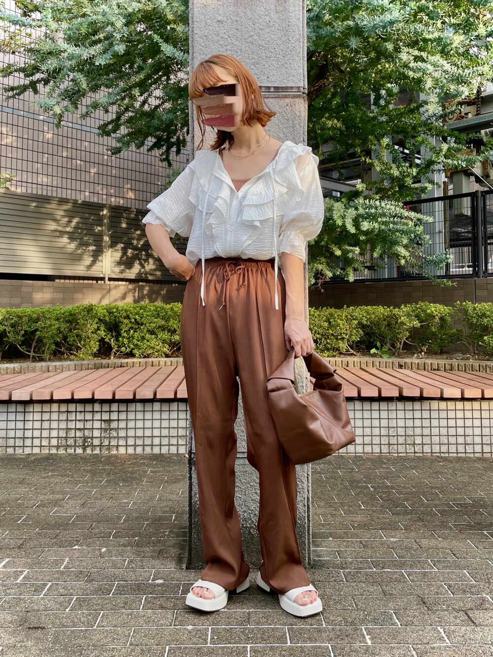 ブラウン系のその他パンツ、ブラック系のハンドバッグ、ホワイト系のサンダルを着用したレディースの秋コーディネートの1枚目の写真