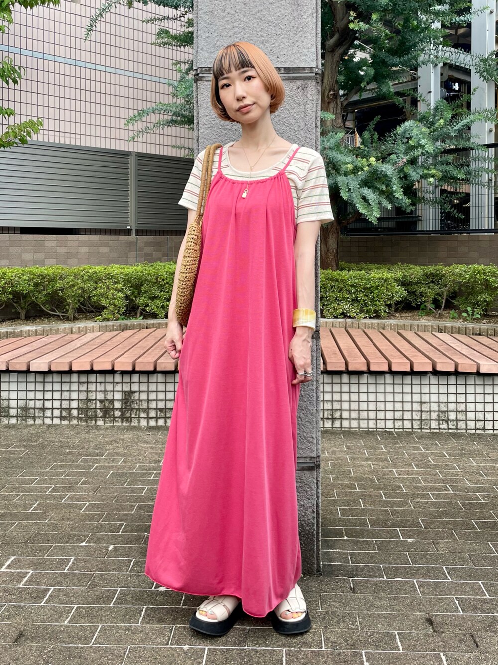 ピンク系のワンピース、ホワイト系のTシャツ/カットソー、ホワイト系のサンダルを着用したレディースの夏コーディネートの1枚目の写真