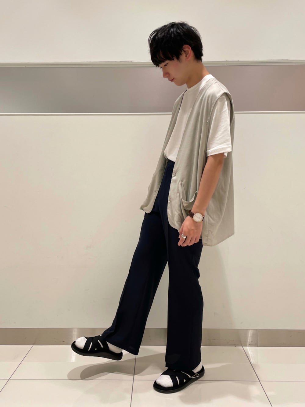 グレー系のベスト、ホワイト系のTシャツ/カットソー、ブラック系のサンダルを着用したメンズの夏コーディネートの1枚目の写真