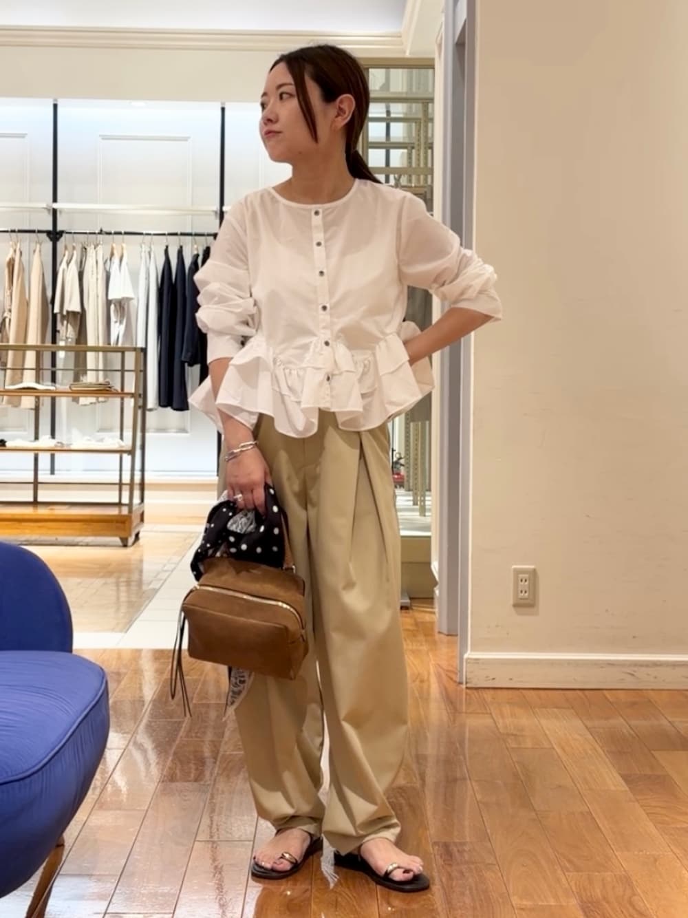 ベージュ系のチノパンツ、ホワイト系のシャツ/ブラウス、イエロー系のショルダーバッグを着用したレディースの夏コーディネートの1枚目の写真