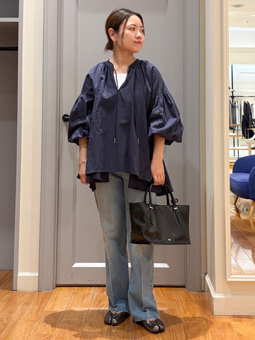 ブルー系のシャツ/ブラウス、ホワイト系のタンクトップ、ブルー系のデニムパンツを着用したレディースの秋コーディネートの1枚目の写真