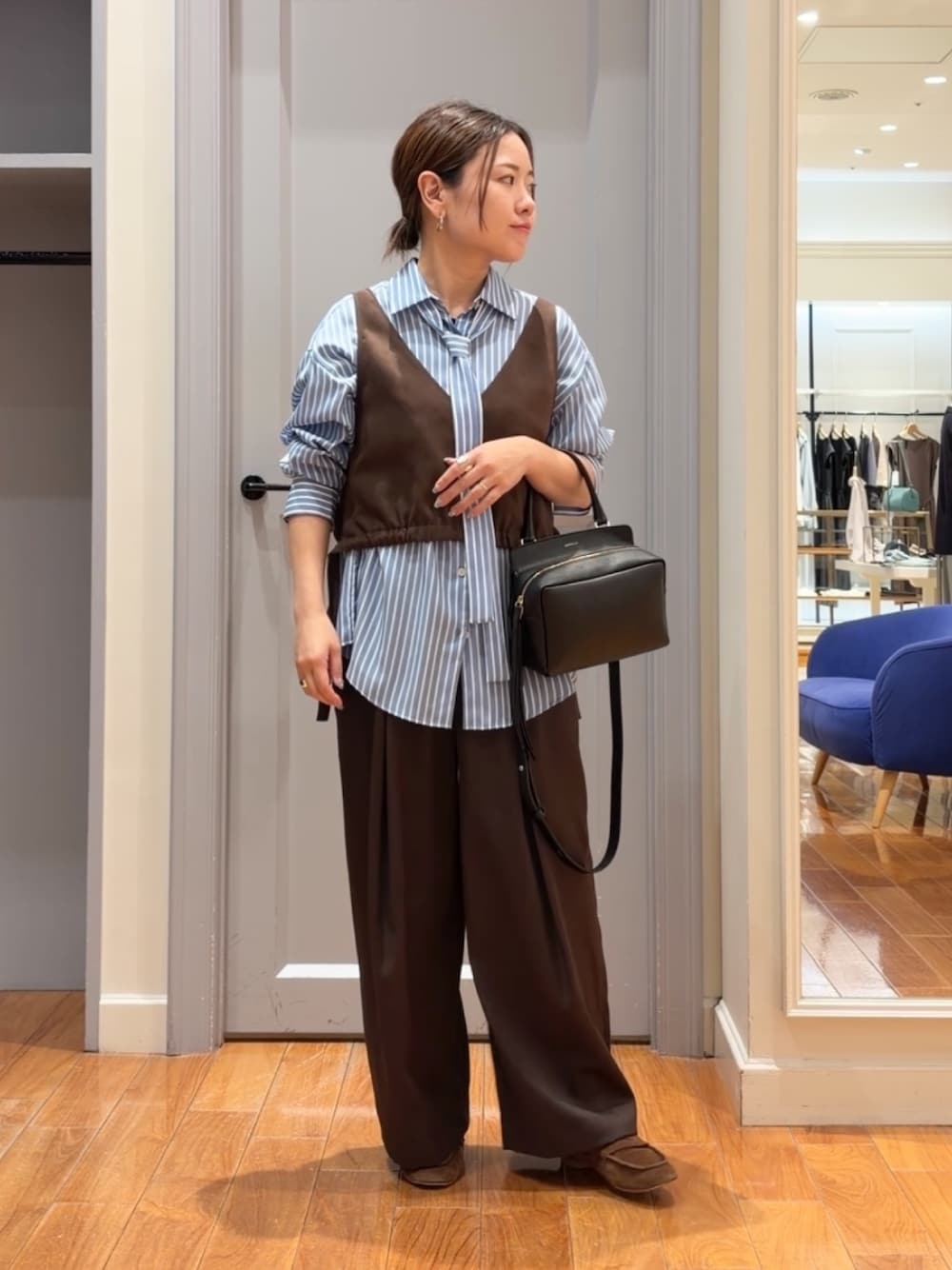 ブルー系のシャツ/ブラウス、ブラウン系のベスト、ブラウン系のその他パンツを着用したレディースの秋コーディネートの1枚目の写真