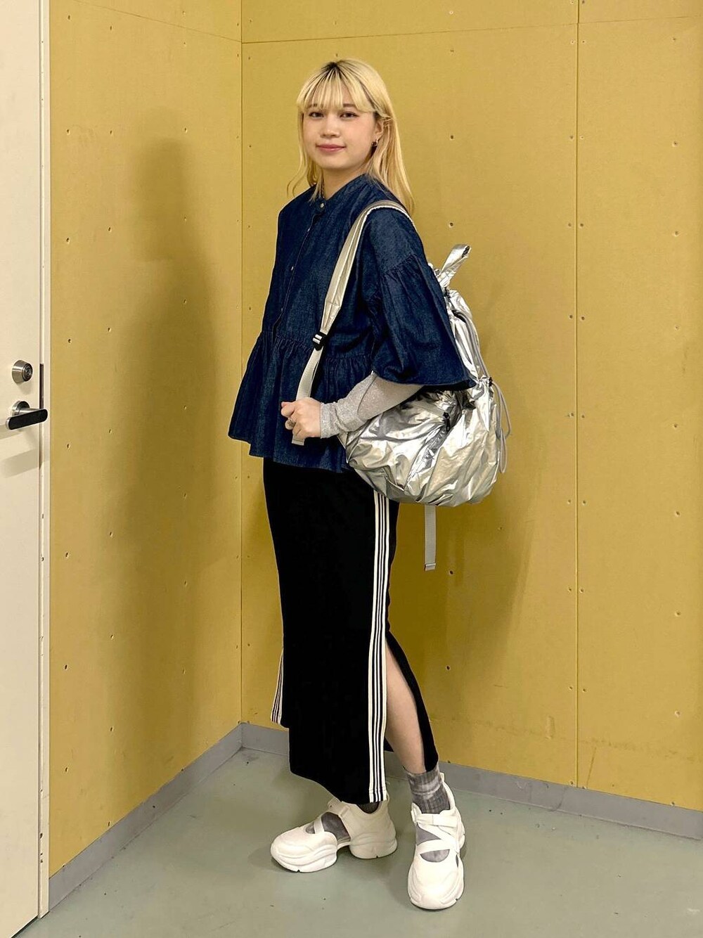 ホワイト系のサンダル、ブラック系のスカート、シルバー系のバックパック/リュックを着用したレディースの春コーディネートの1枚目の写真