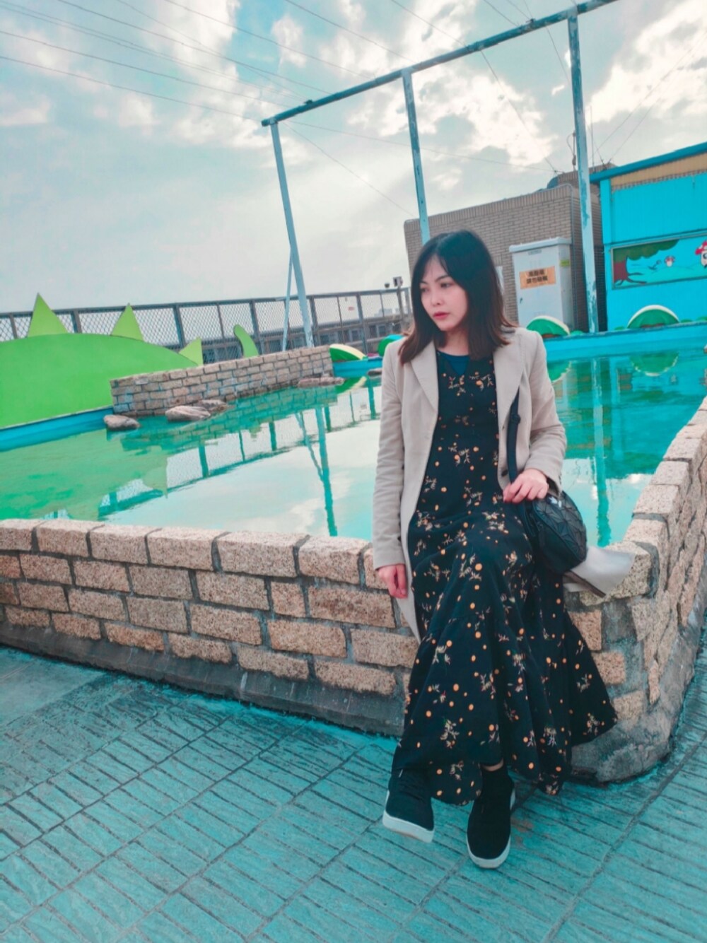 ブラック系のショルダーバッグ、グレー系のチェスターコートを着用したレディースの冬コーディネートの1枚目の写真