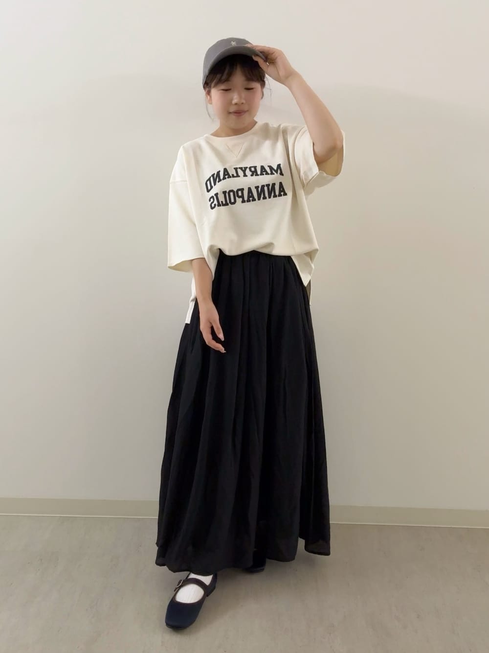 ブラック系のスカート、ホワイト系のTシャツ/カットソー、ブルー系のパンプスを着用したレディースの秋コーディネートの1枚目の写真