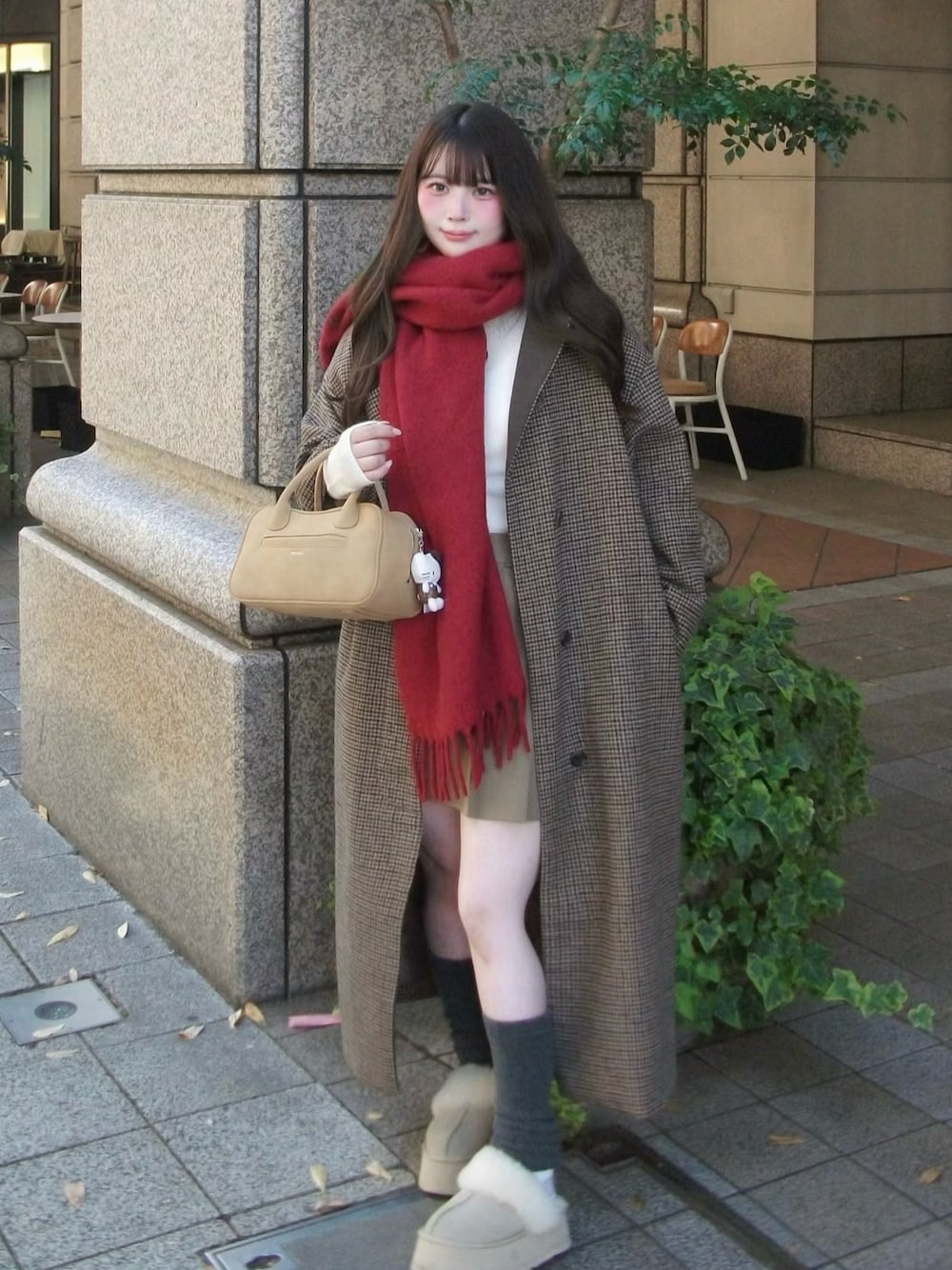 ベージュ系のブーツ、ブラウン系のノーカラーコート、ベージュ系のボストンバッグを着用したレディースの冬コーディネートの1枚目の写真